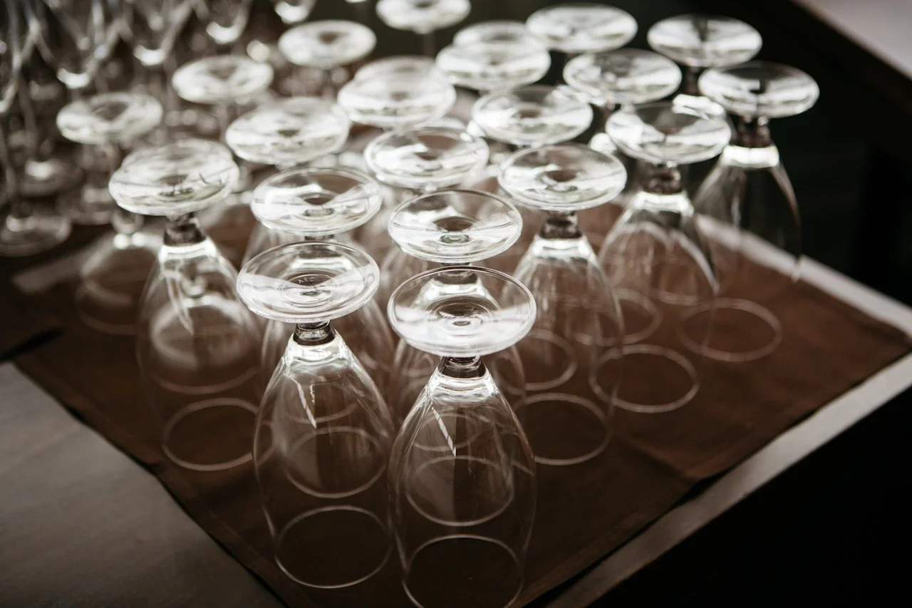 Multiple upside-down wine glasses on a wooden surface