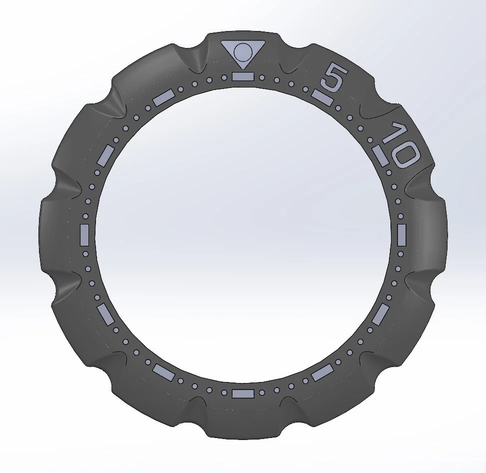 Close-up of a black rotating bezel with numerical markers and dots, used on a diving watch.