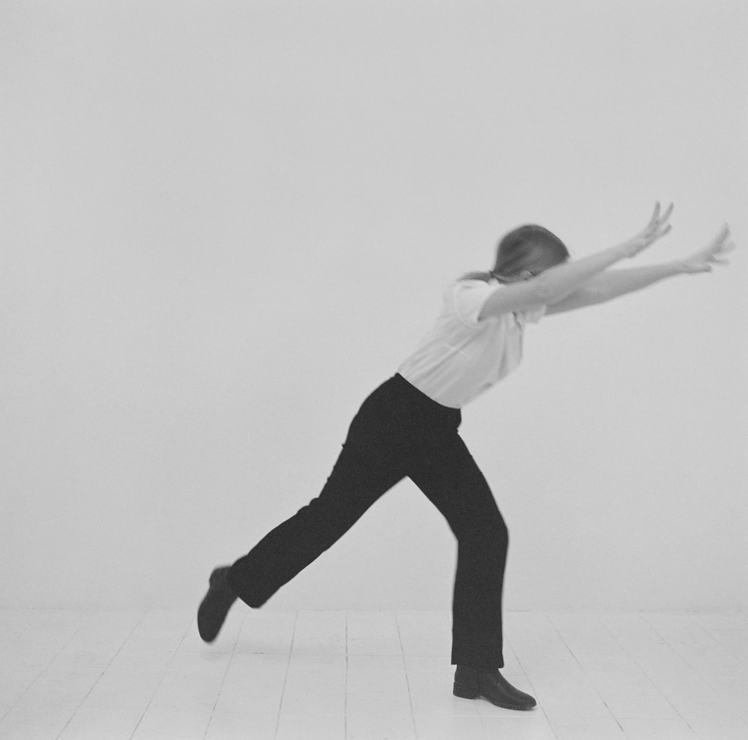 Jeune fille réalisant un geste d'autodéfense dans un studio, photographie argentique noir et blanc de Lucie Belarbi.