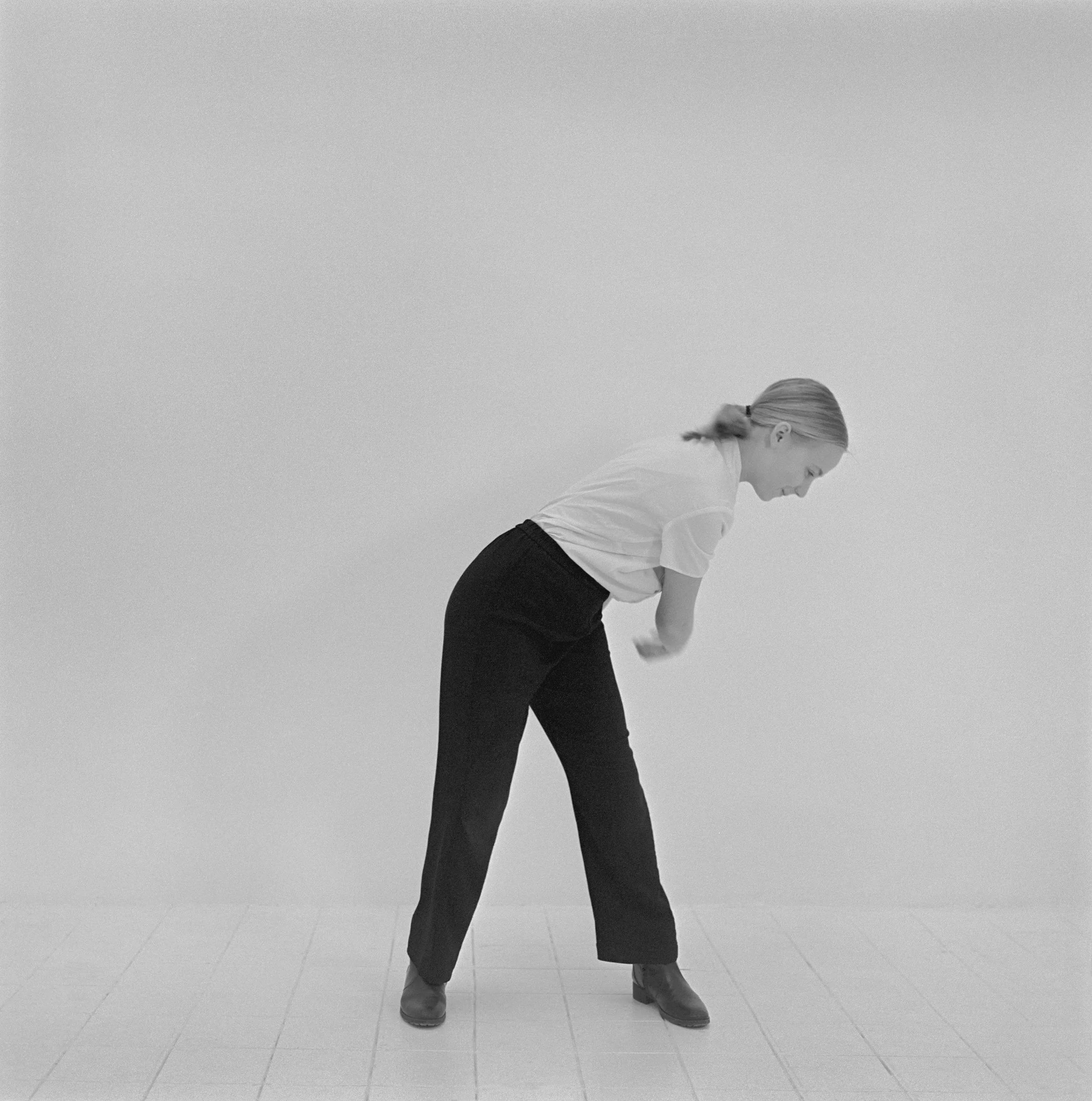 Jeune fille réalisant un geste d'autodéfense dans un studio, photographie argentique noir et blanc de Lucie Belarbi.