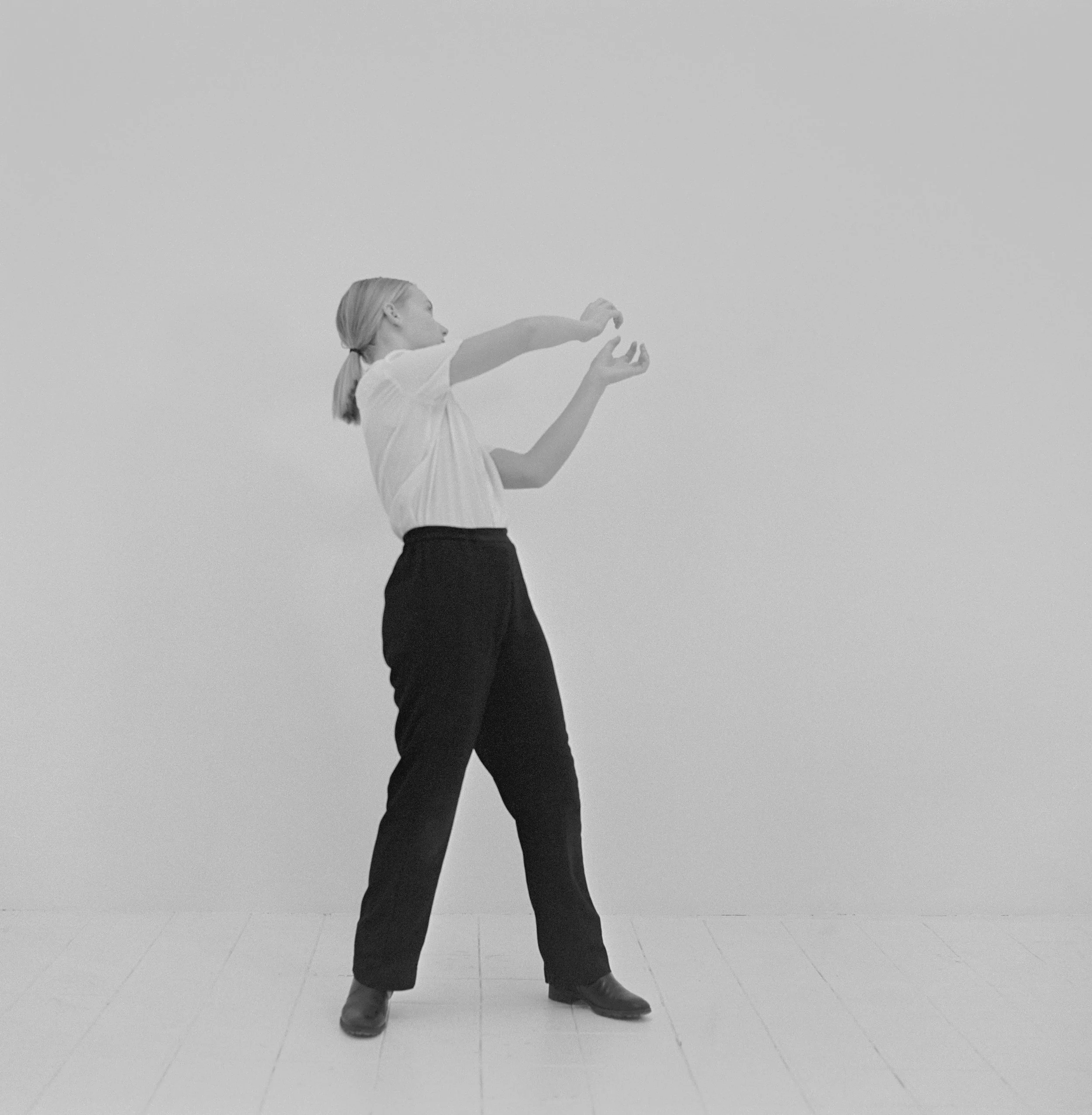 Jeune fille réalisant un geste d'autodéfense dans un studio, photographie argentique noir et blanc de Lucie Belarbi.