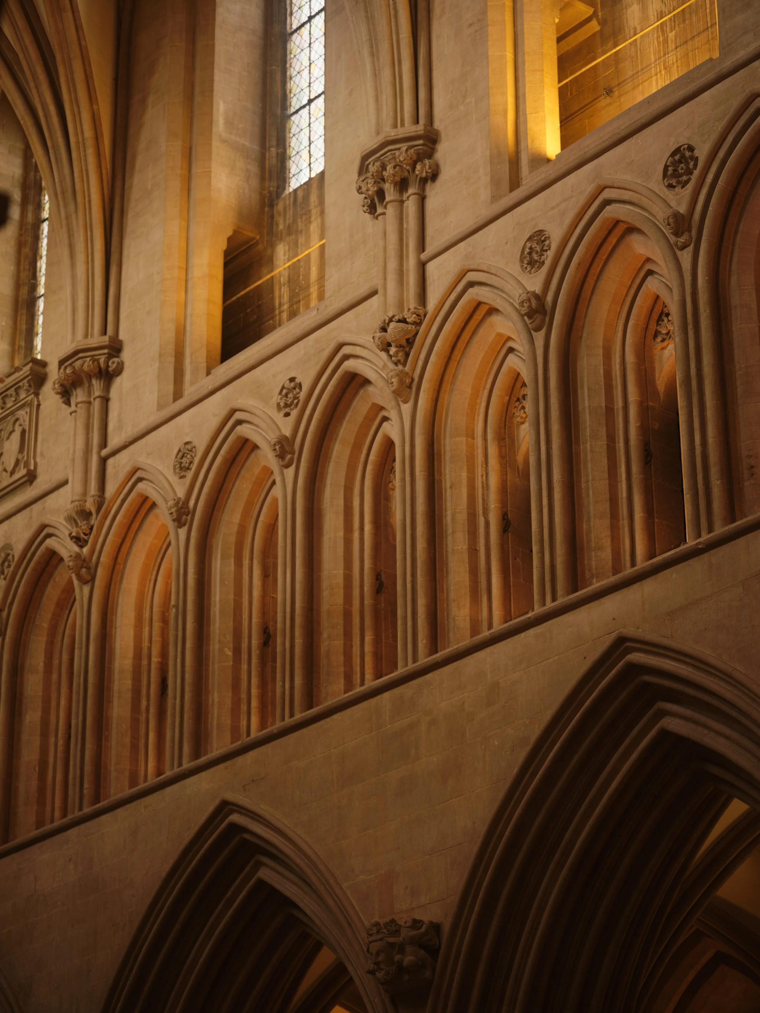 Interior of a historic cathedral or church with Gothic arches, decorative columns, and stained glass windows.