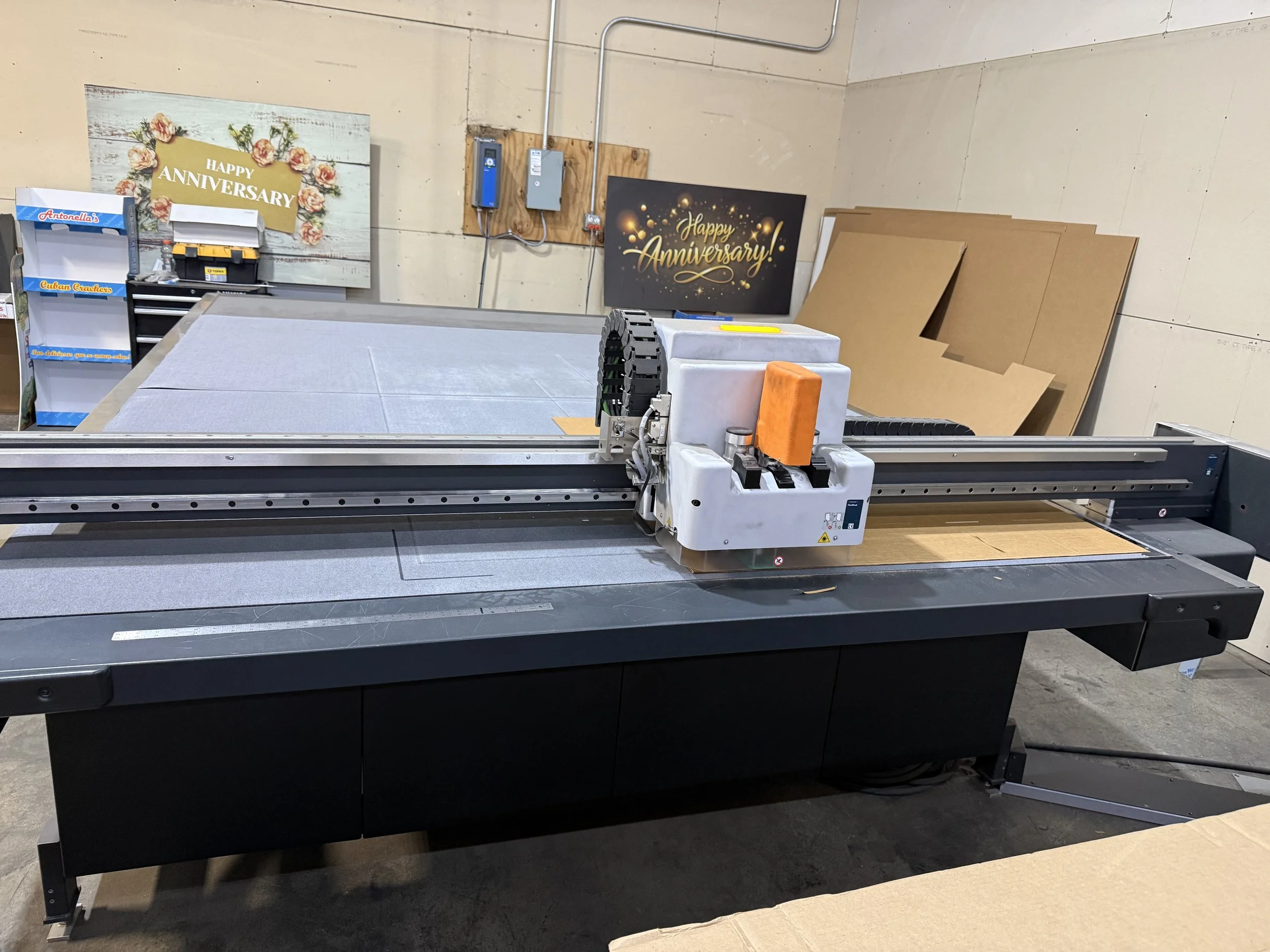 A large industrial cutting machine , CAD table, samples