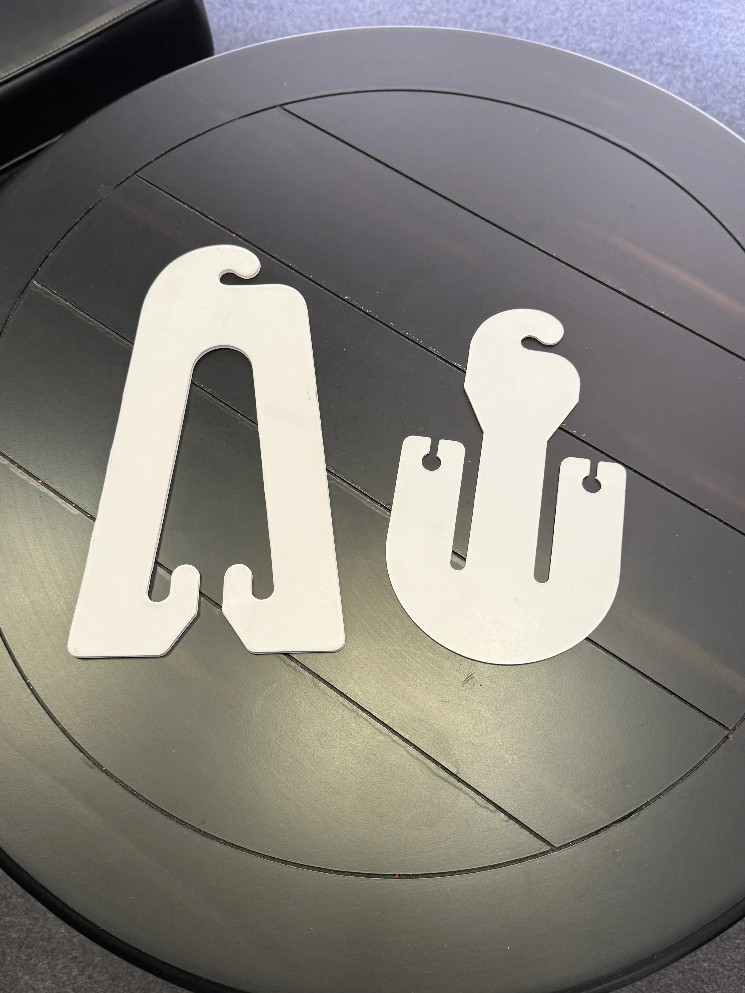 Metal letters arranged to spell 'AC' on a wood surface.