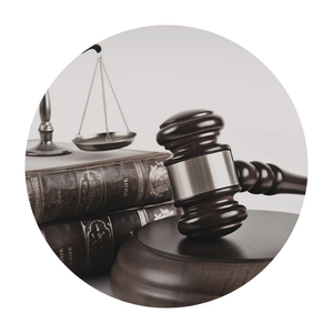 Gavel resting on legal books with a balance scale in the background, symbolizing justice and law.