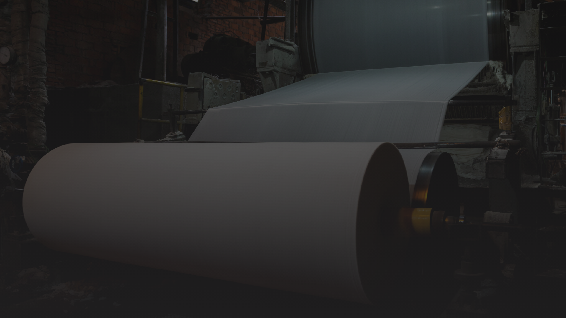 Fábrica de papel com uma grande bobina de papel sendo produzida na impressora industrial.