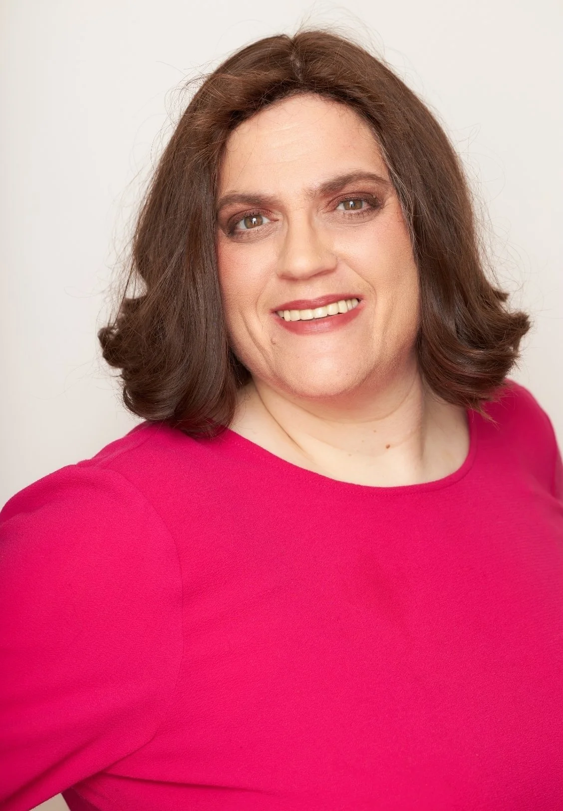 Rivkah Cunin, couples therapist in Los Angeles, wearing a bright pink top, smiling at the camera.