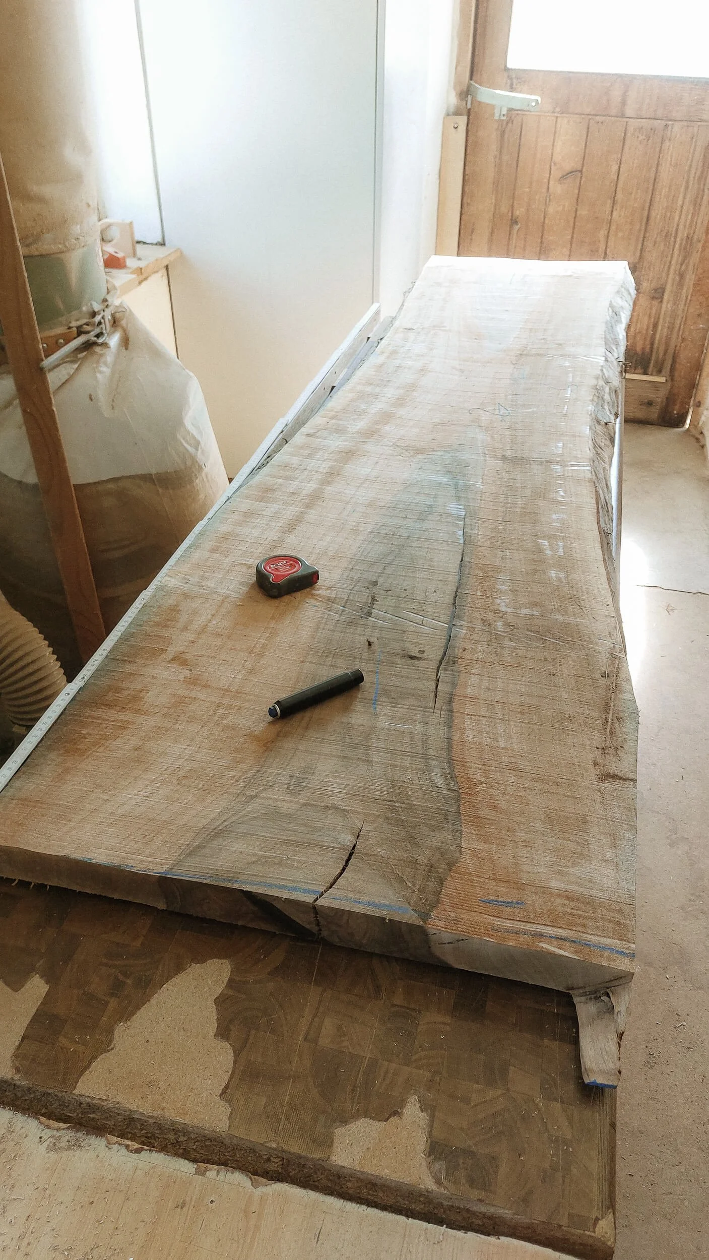 Holztisch in der Werkstatt mit Messwerkzeug und Filzstift auf der Oberfläche