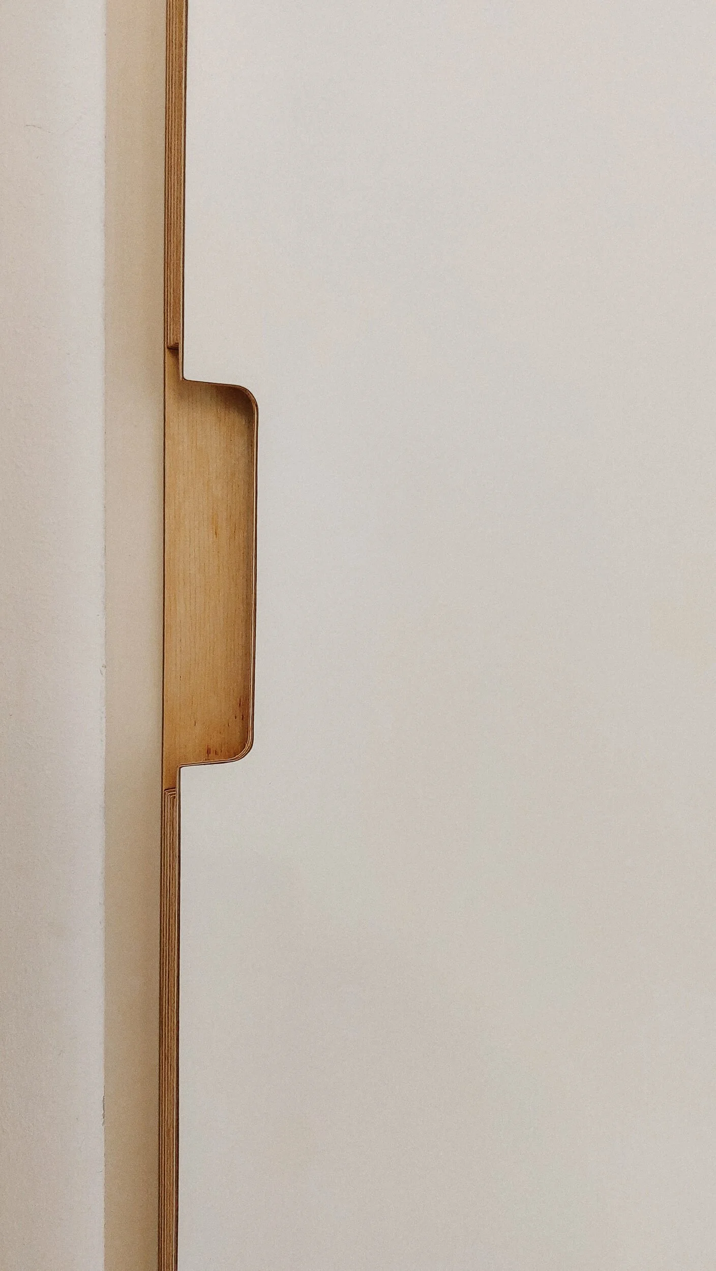 Ein weißer Schreibtisch mit einer versteckten Schublade aus Holz, die in die Oberfläche integriert ist.