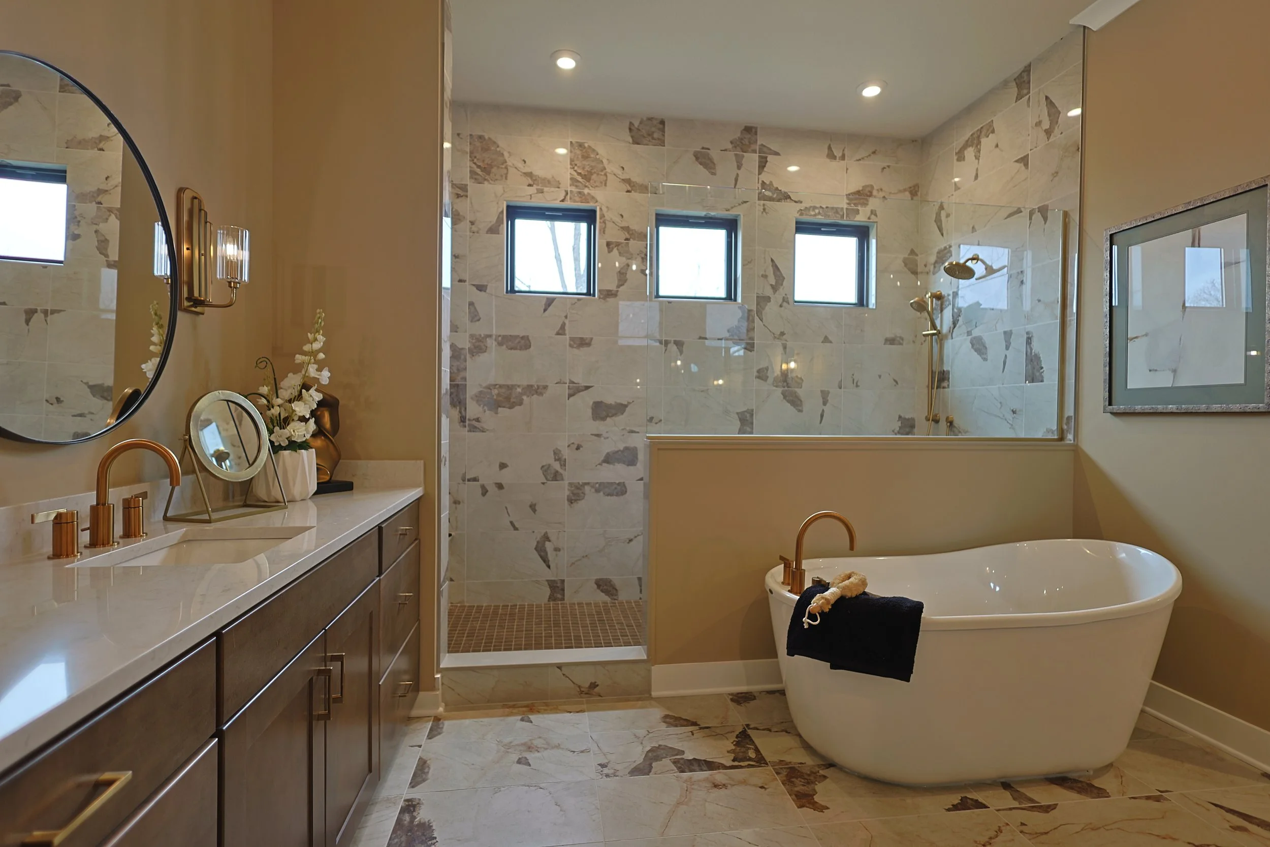Modern bathroom with vanity, mirror, toilet, and walk-in shower with small windows and marble tiles