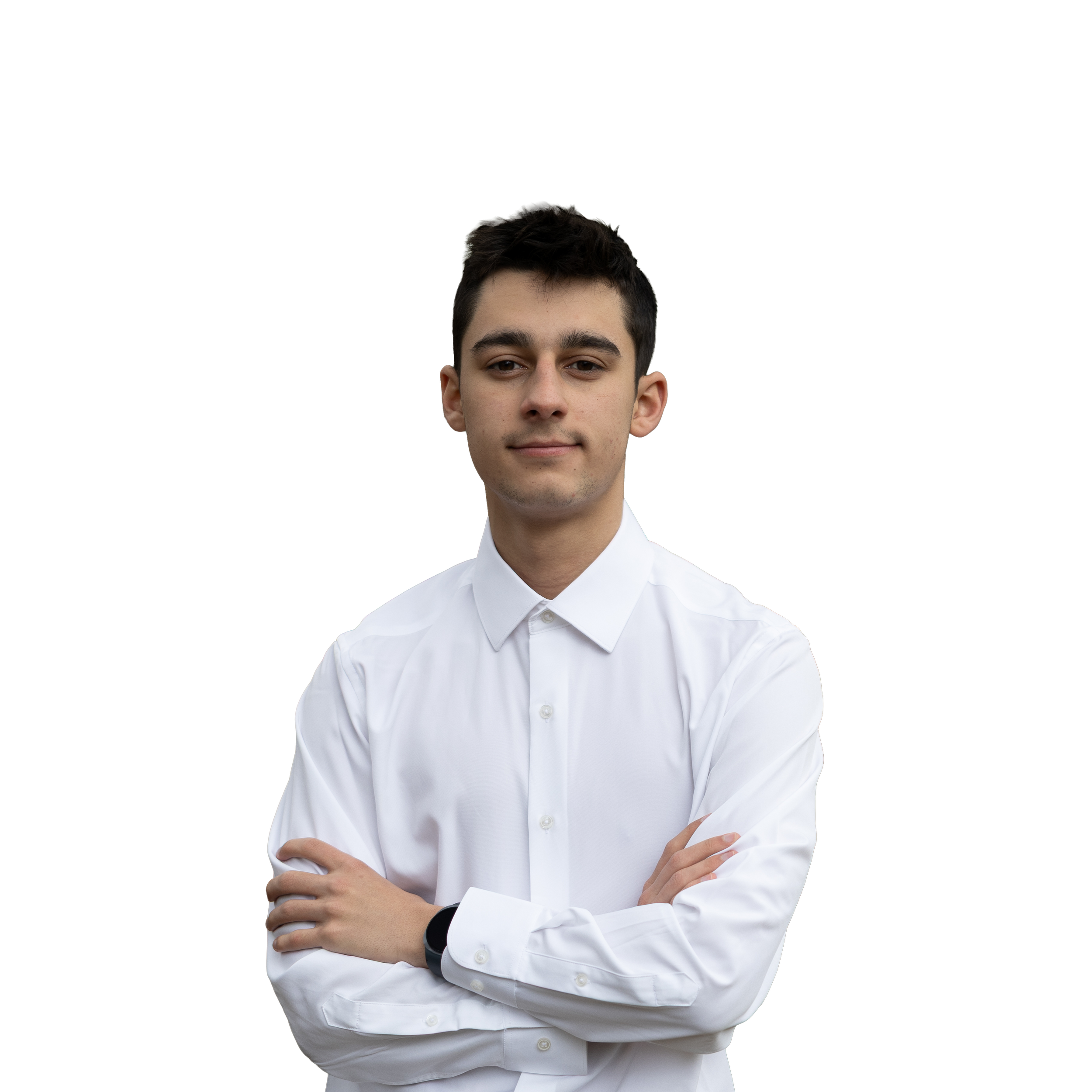 Portrait of a young man with dark hair, wearing a white dress shirt, standing with crossed arms against a black background.