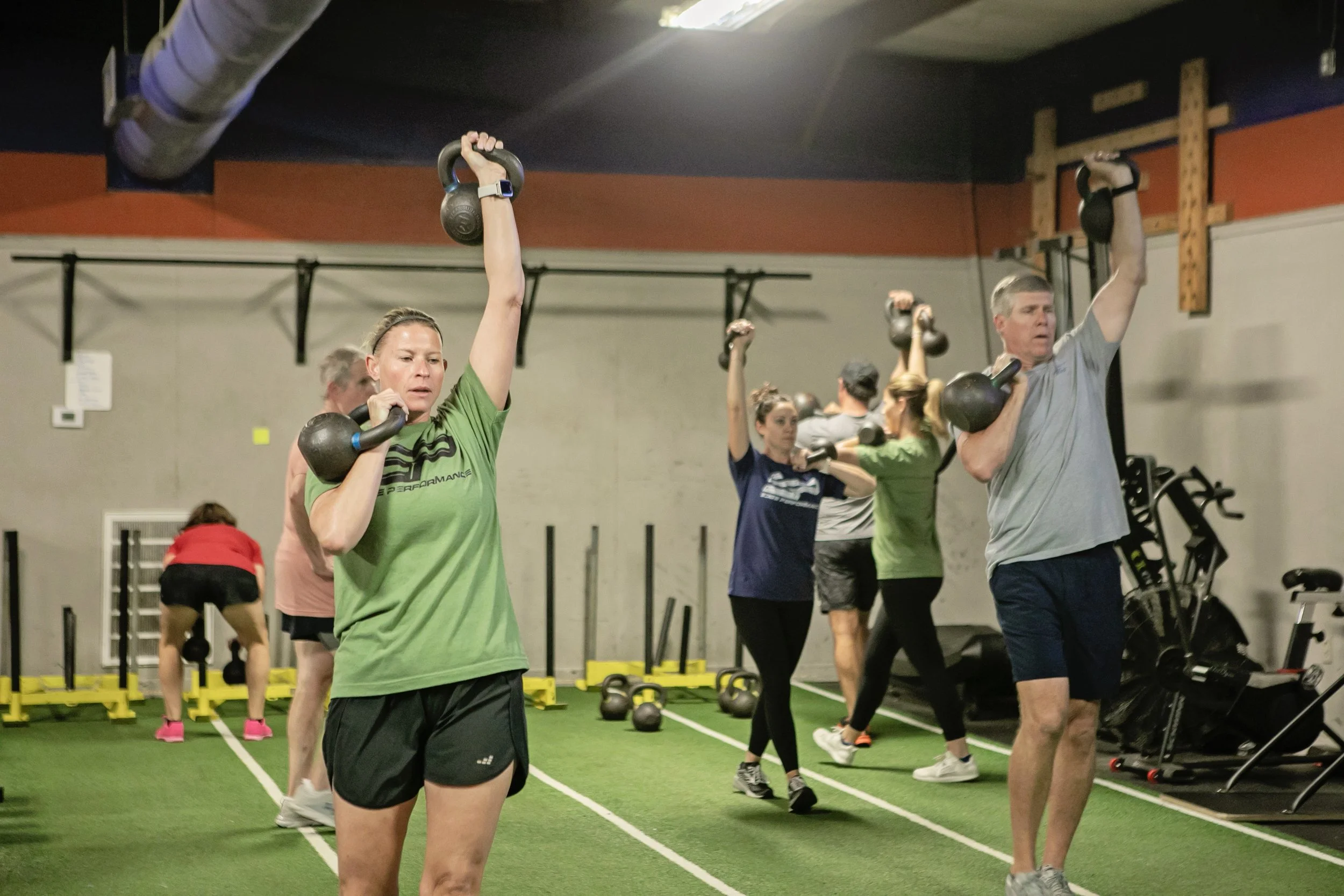 Adults working out with kettlebells at the Edge Performance Valdosta gym.
