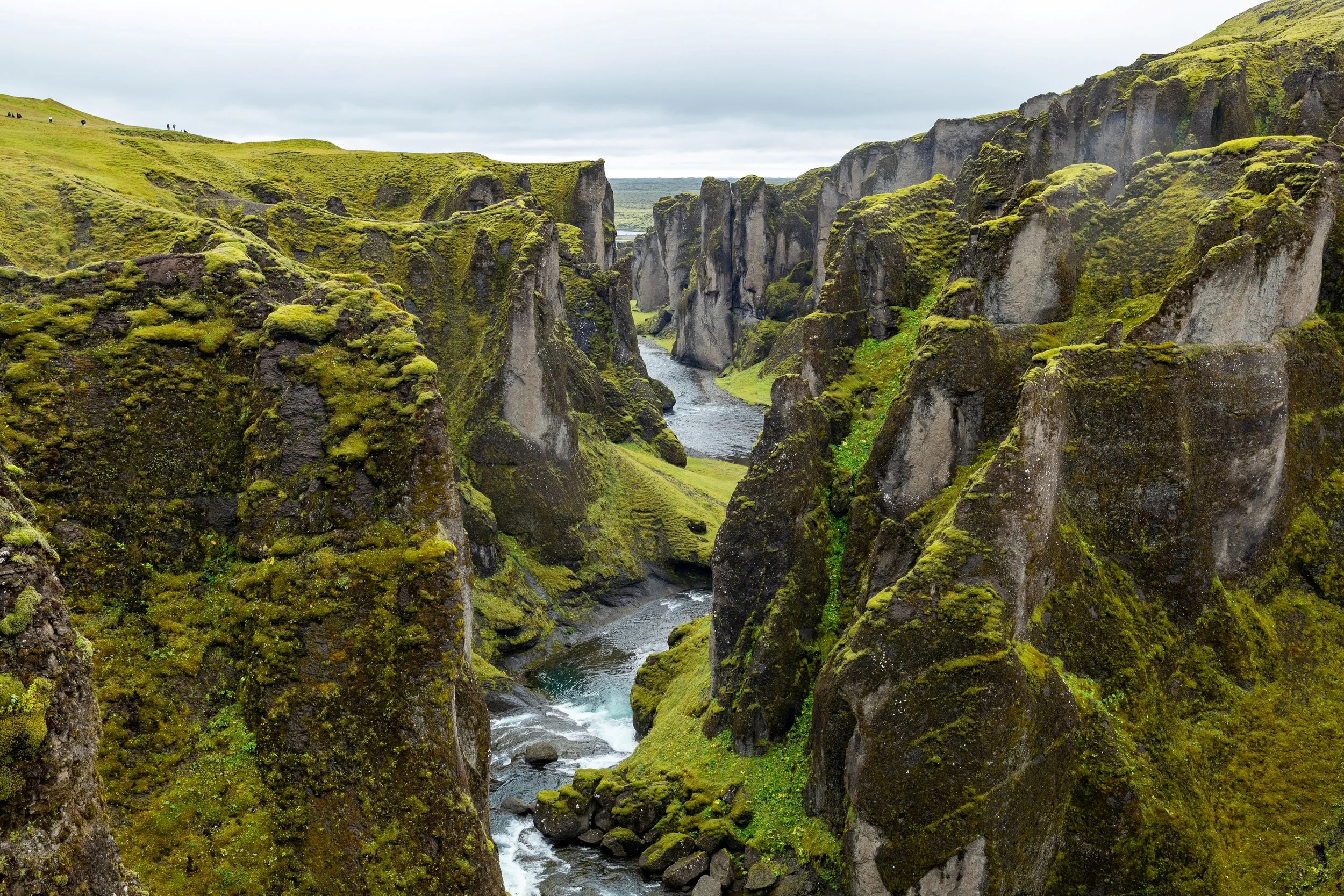 Green moss-covered cliffs surrounding a river canyon.