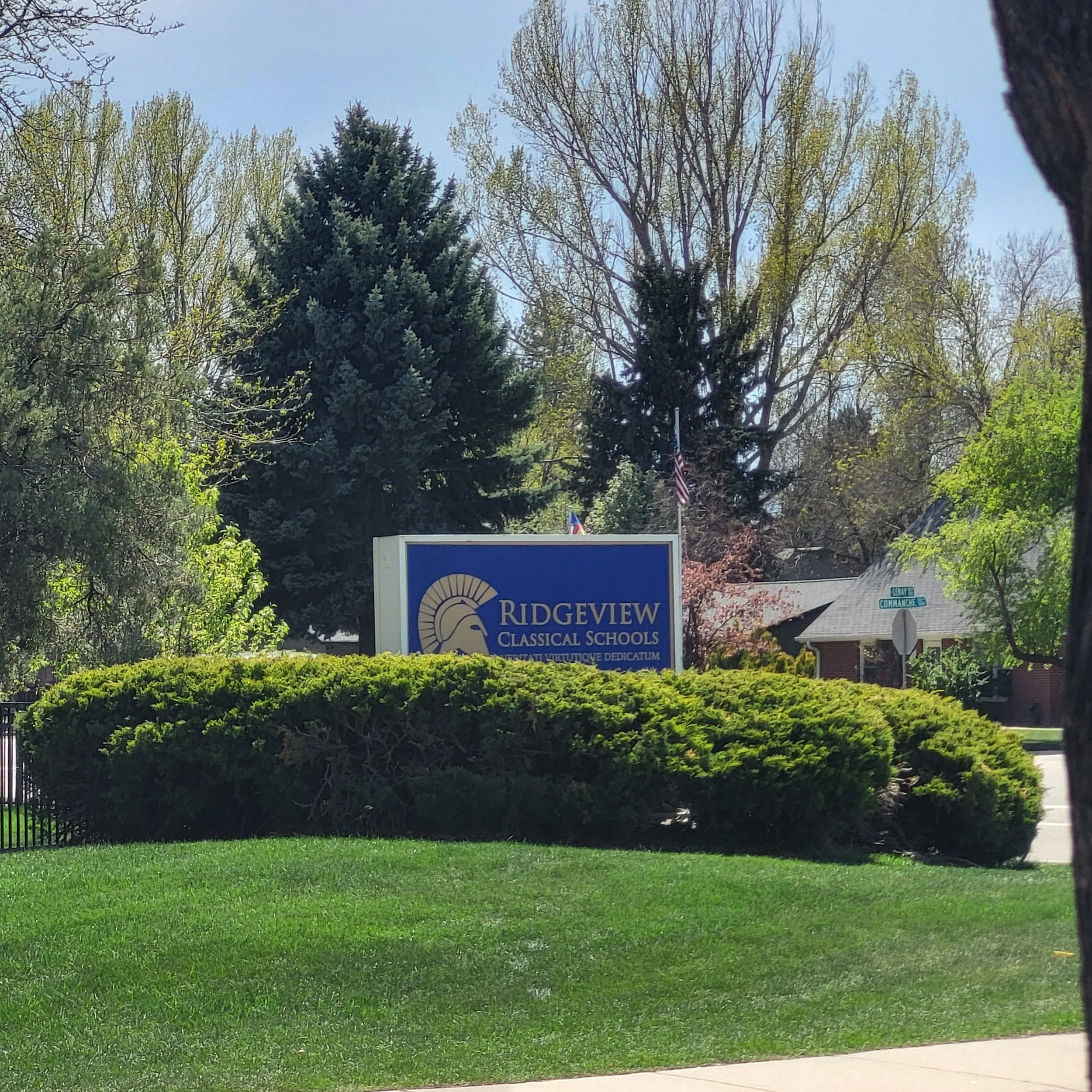 Sign for Ridgeview Classical Schools with trees and residential houses in the background.
