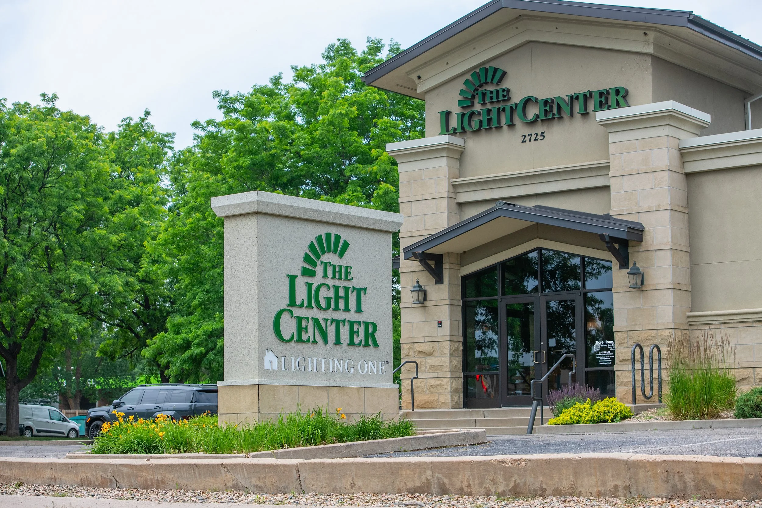 The exterior of a building with a sign reading 'The Light Center' and the address 2725, surrounded by trees and parking lots.