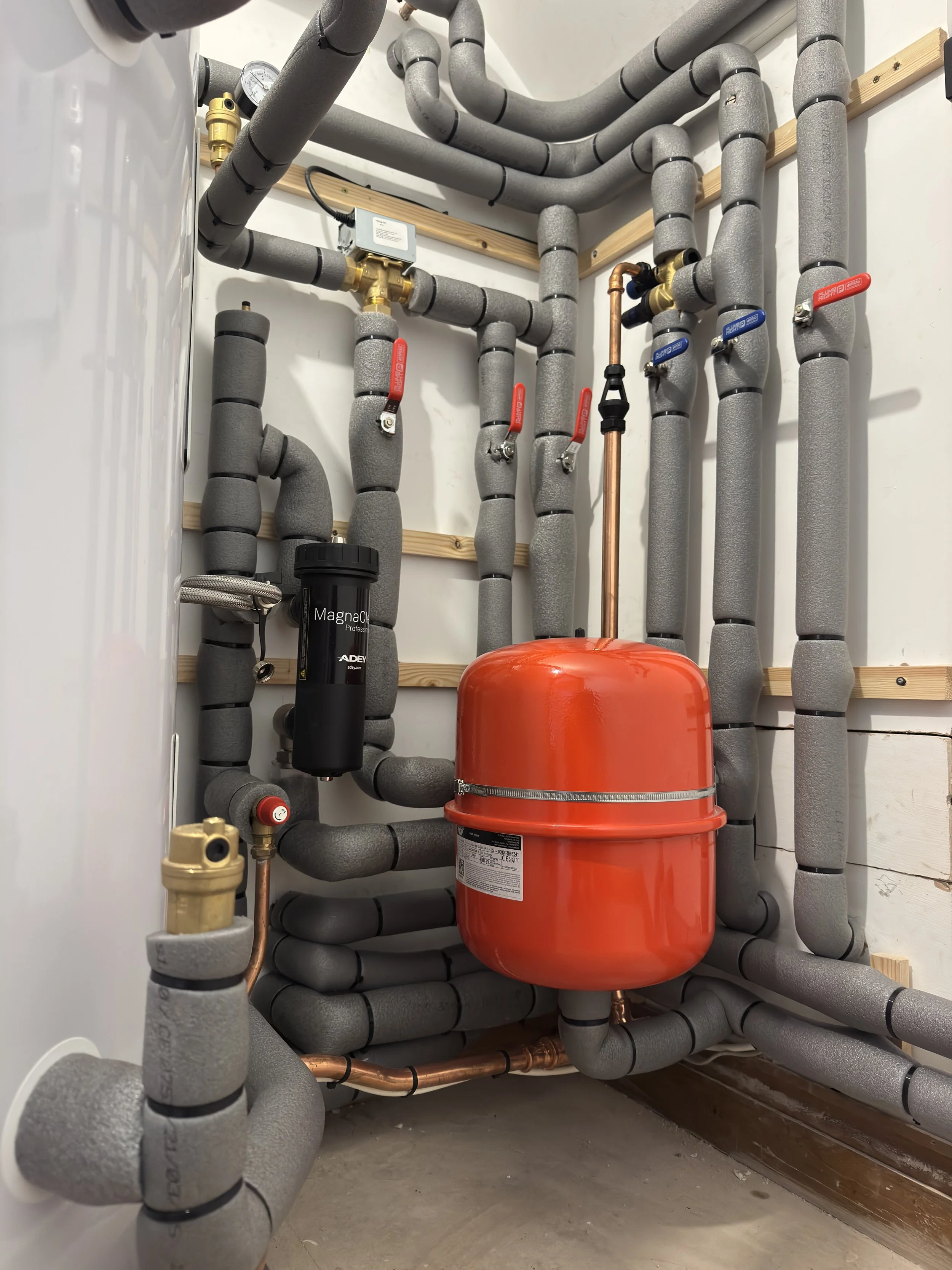 inside a airing cupboard with a vaillant heat pump unvented cylinder, pipework and expansion vessel