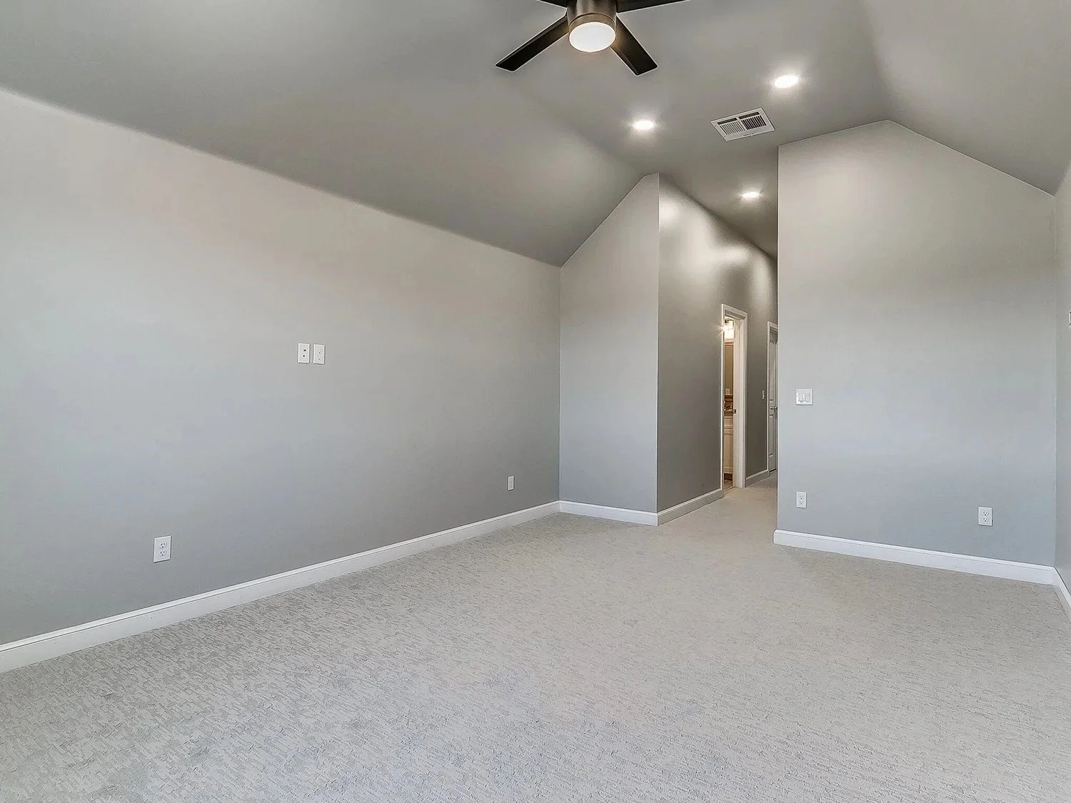 Empty room with light gray walls, white baseboards, ceiling fan, recessed lighting, and a doorway in the corner.