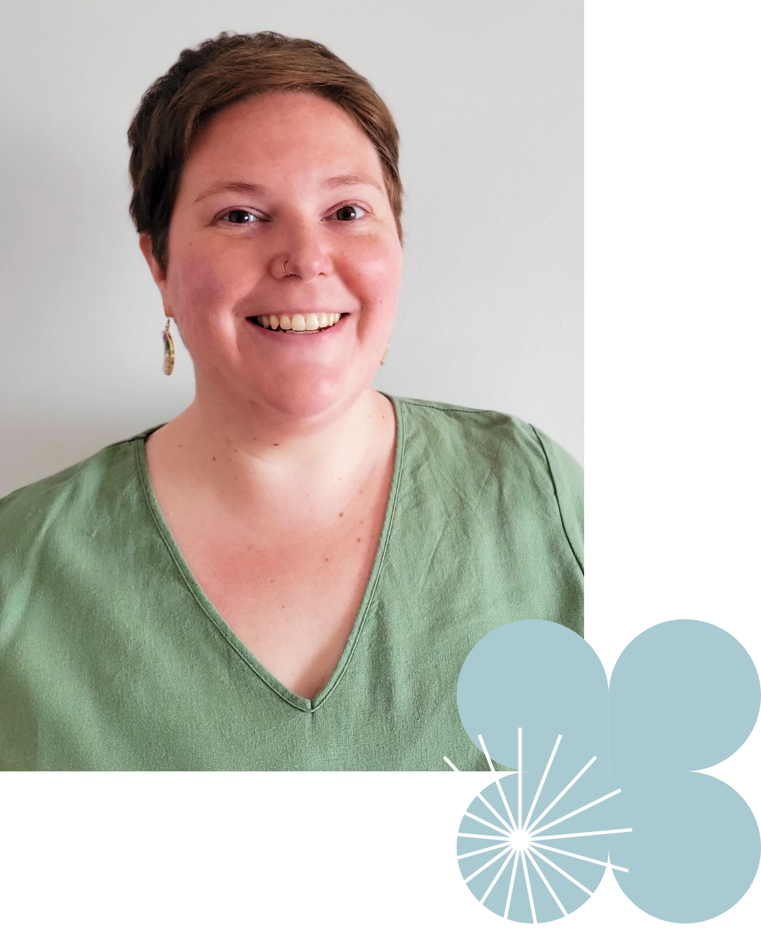 Katelyn Owen with short brown hair, smiling while wearing a green V-neck top and earrings, standing against a plain white wall.