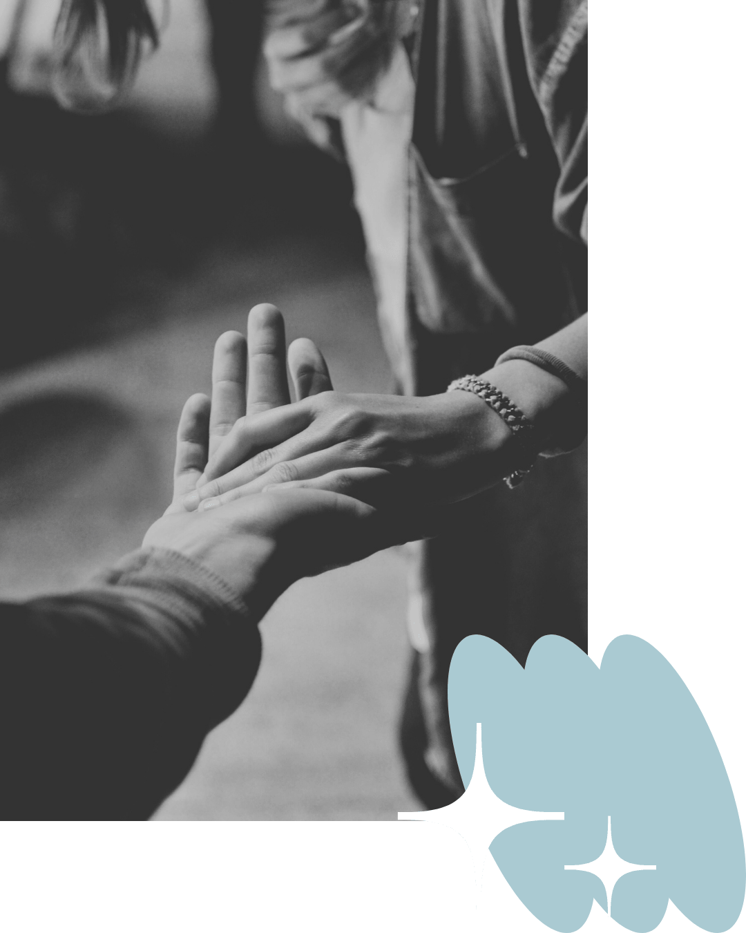 Black and white photo of two people holding hands, with one hand placed over the other.