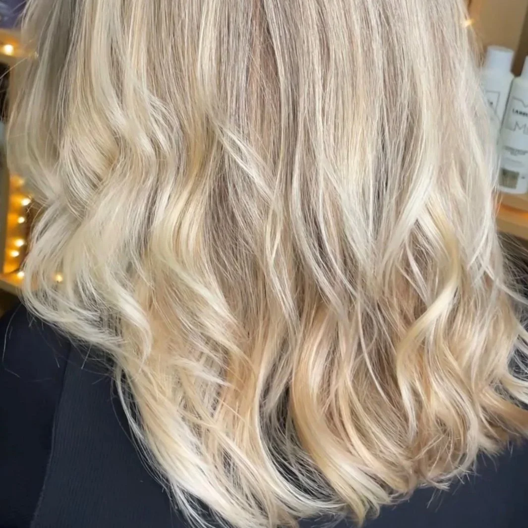 Close-up of blonde, wavy, shoulder-length hair.