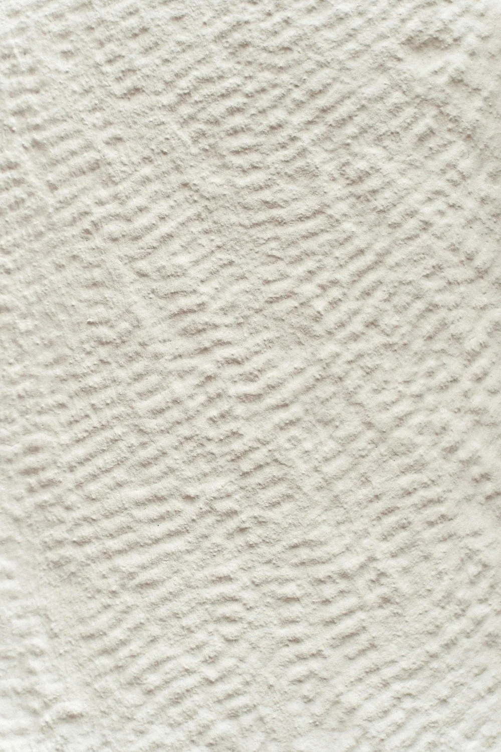 Close-up of textured white wall with horizontal ridges.
