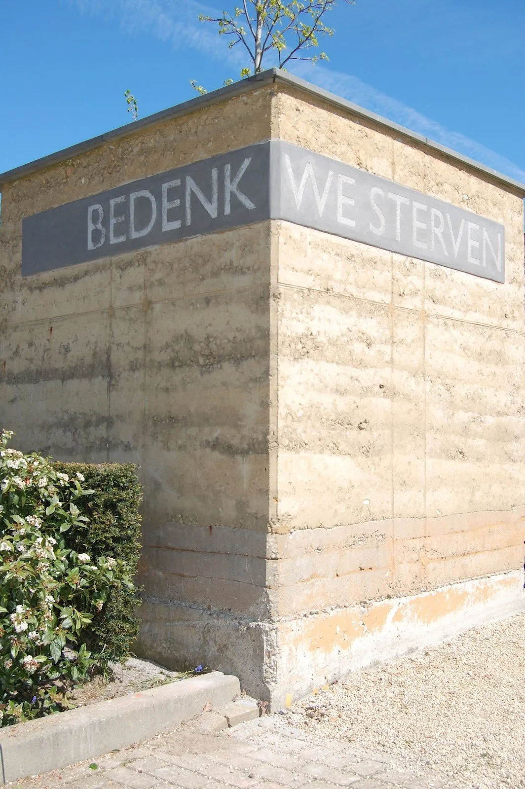 Gedenkmuur van gestampte aarde op begraafplaats Spijk, gemeente Lingewaal, uitgevoerd in stampleem