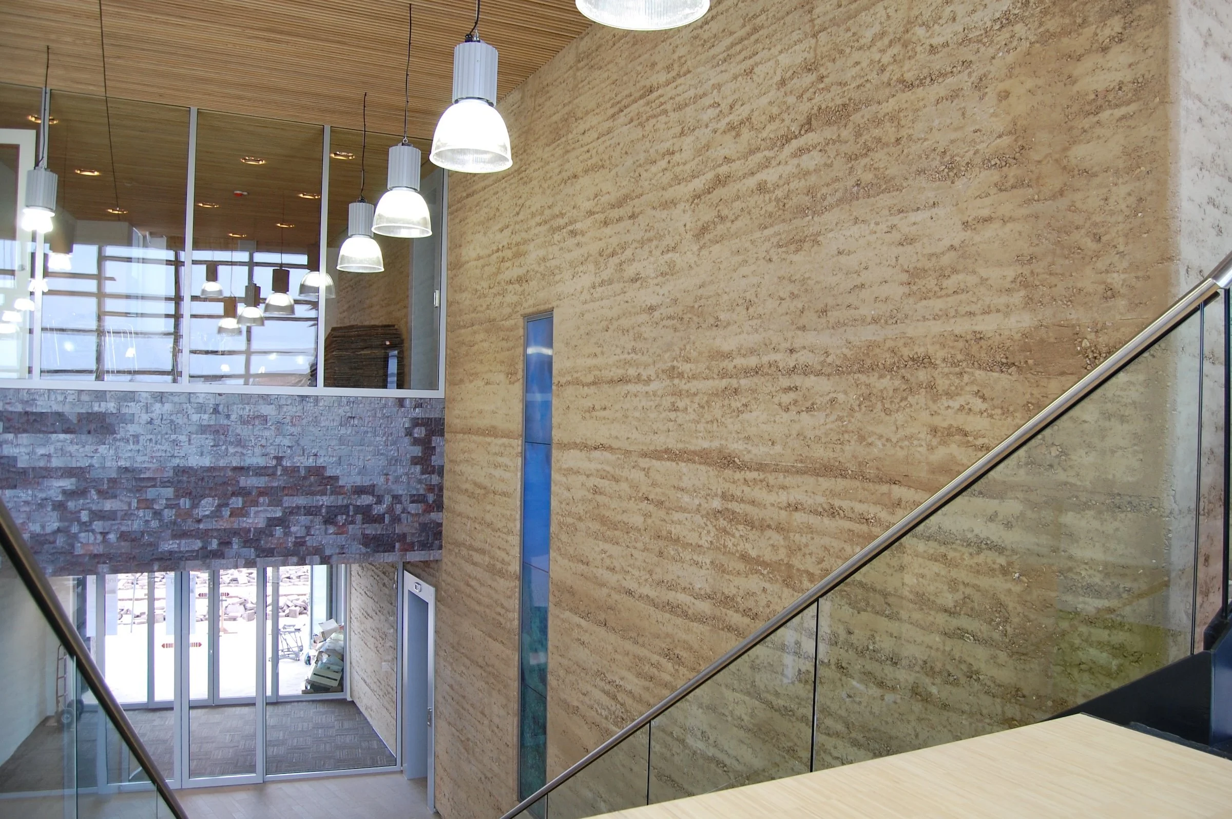 Interieur van een modern gebouw met een grote stampleem ofwel rammed earth wand