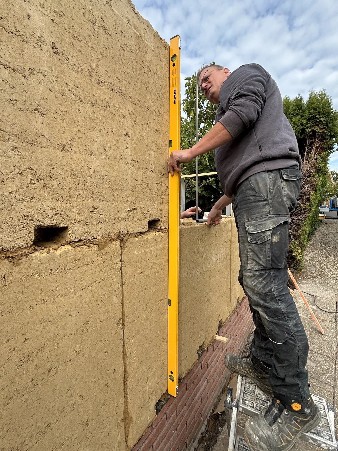 Bouw aannemer die een EuroLeem stampleem element aan het plaatsen is voor een biobased bouwproject.