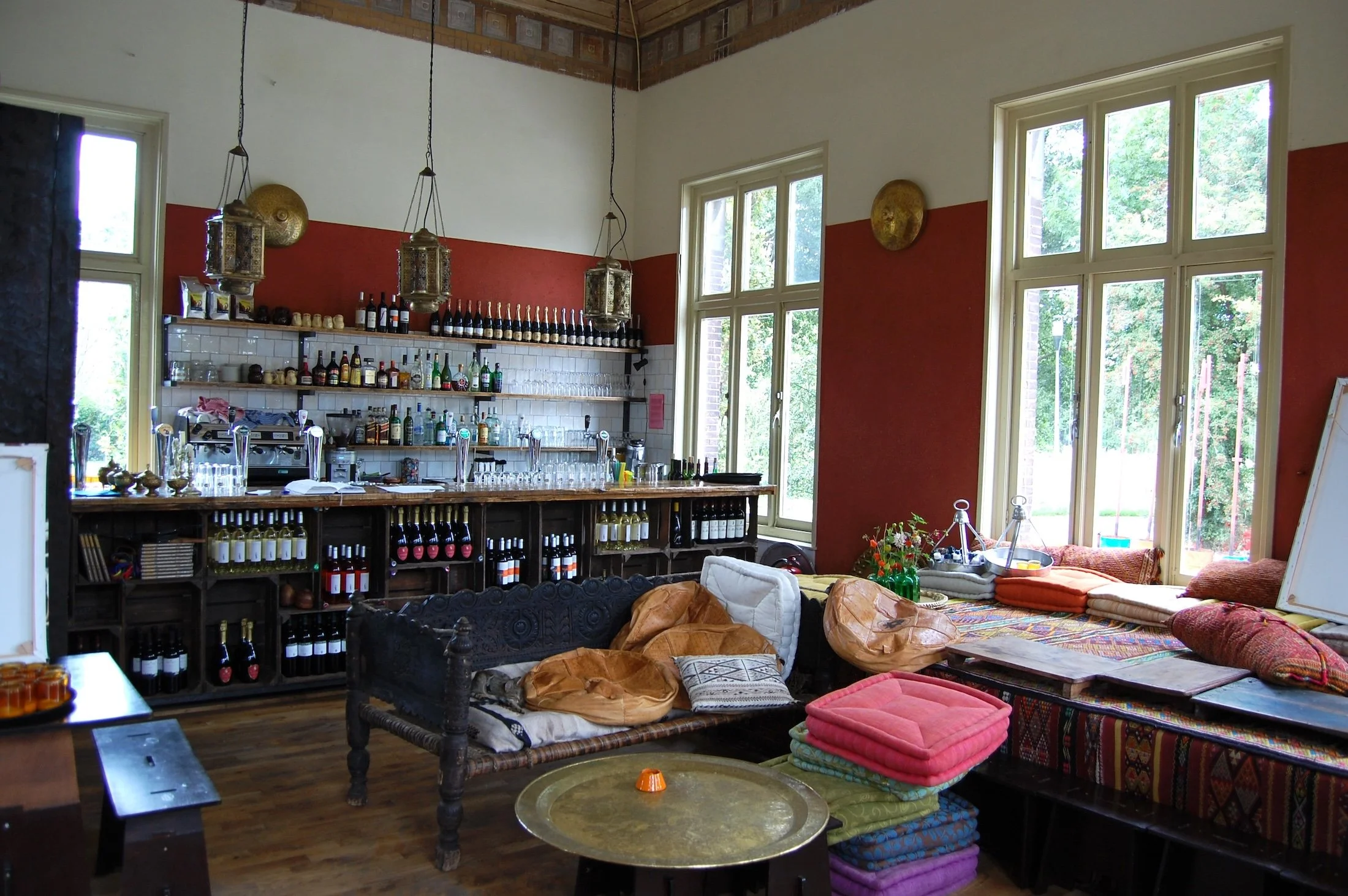 Restaurantinterieur met leemstuc wanden in rode pigmenten en natuurlijke strodetails