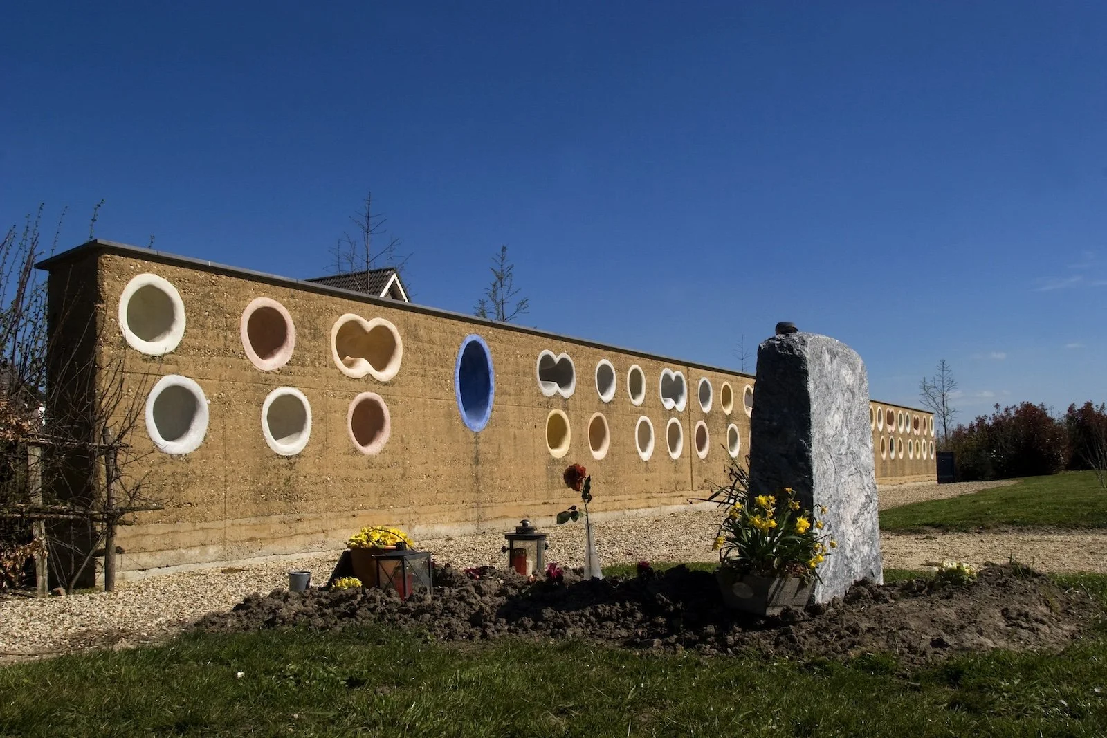 Urnen wand van rammed earth met aardse kleuren en ambachtelijke verdichtingstechniek