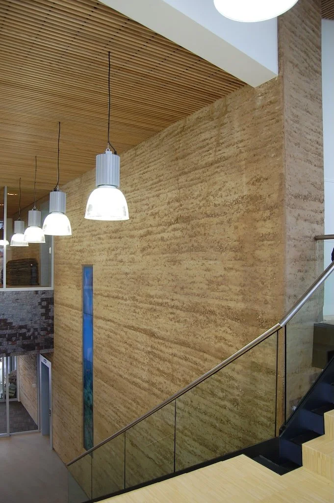 Stampleem wand uitgevoerd in natuurlijk rammed earth met zichtbare aardlagen