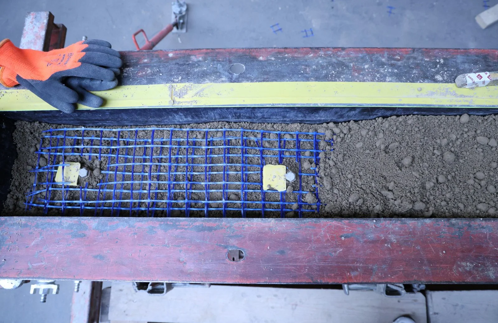 Op maat gemaakte bekisting gevuld met leem, klei, zand en aarde voor mechanische verdichting door Euroleem in bouwplaats.