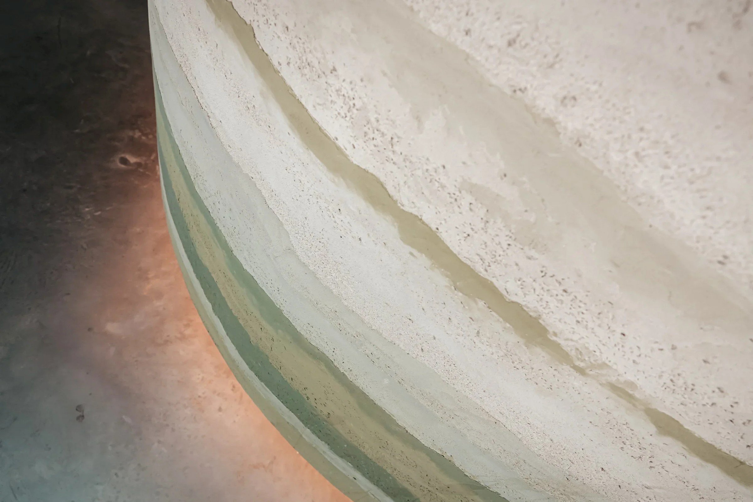 Close-up van een muur met droge pleisterlaag van leem. Deze muur lijkt op stampleem maar is een lemen muur met pigmenten, genaamd stampleem look, waarbij stampleem wordt geimiteerd.
