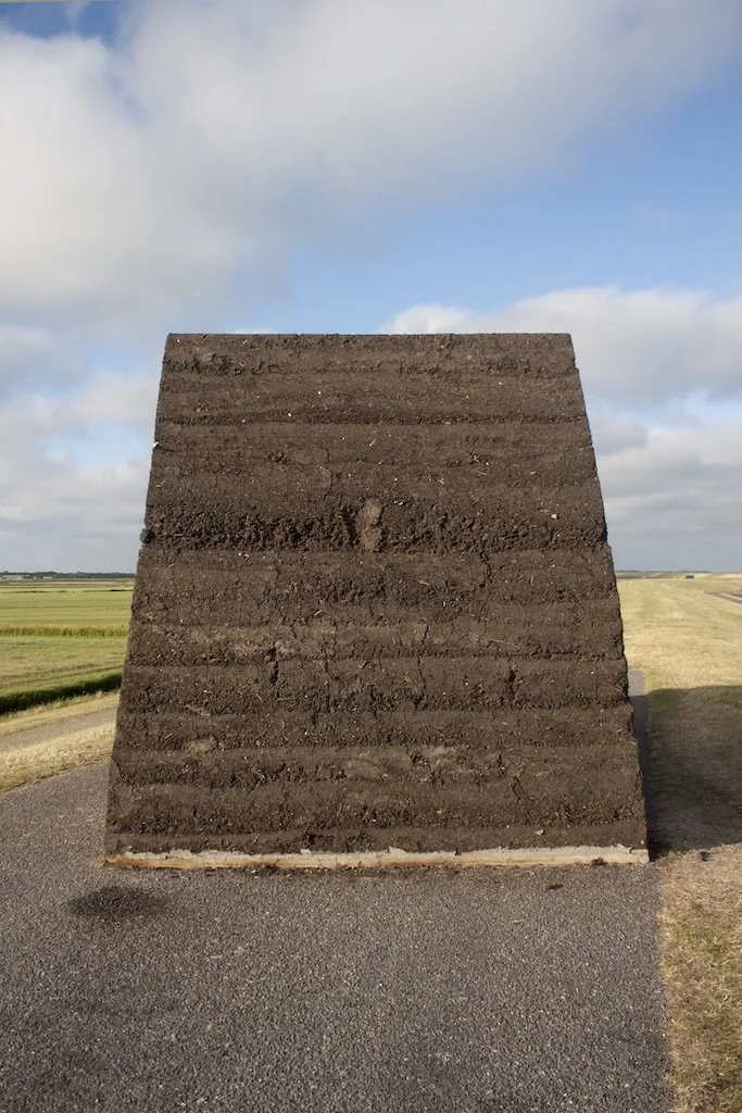 Biobased kunsttoepassing in stampleem met zichtbare lagen van aarde en mineralen