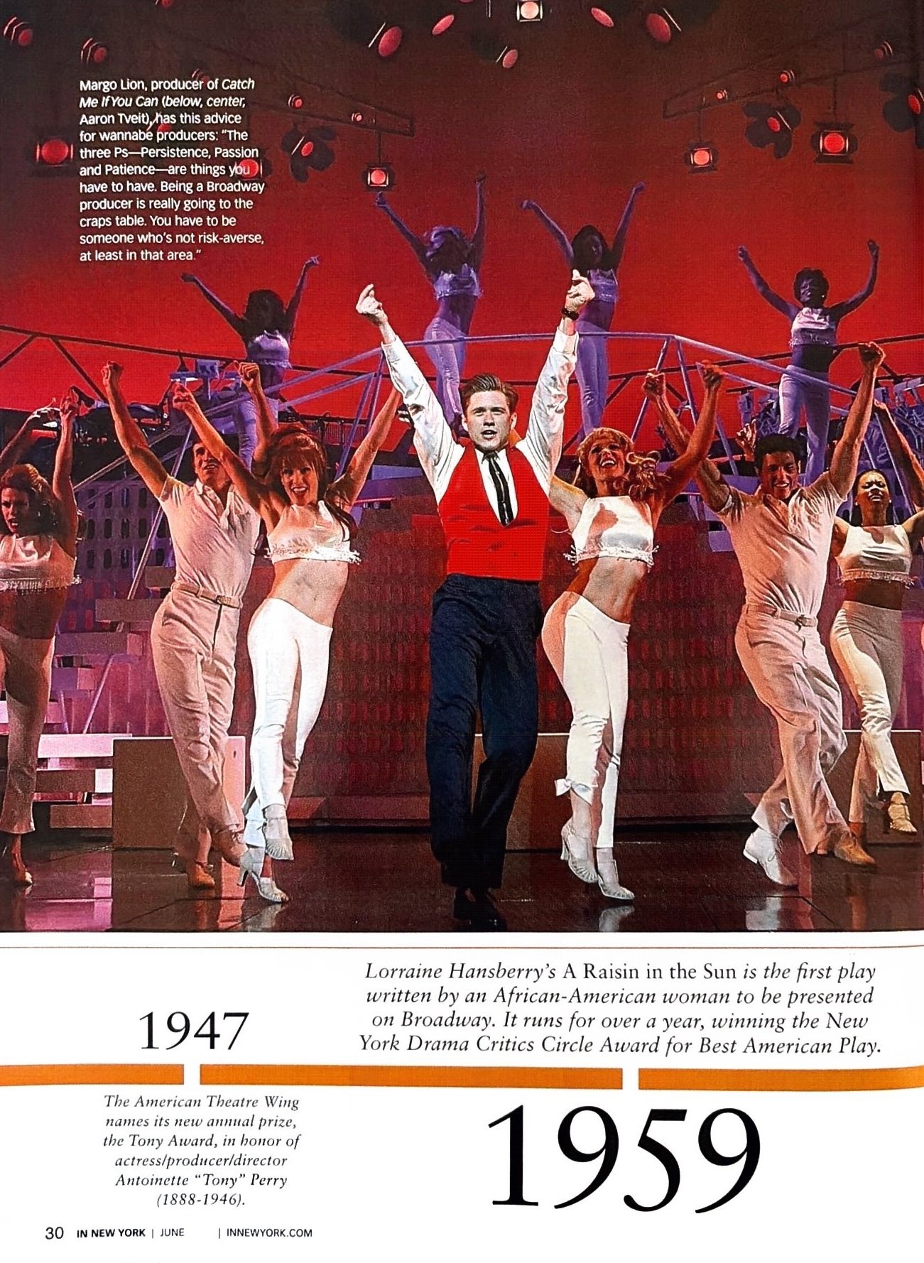 A stage scene from Lorraine Hansberry's play 'A Raisin in the Sun' with actors performing, featuring one male actor in a red vest center stage and surrounded by female actors in white outfits with arms raised, and additional performers in the background.