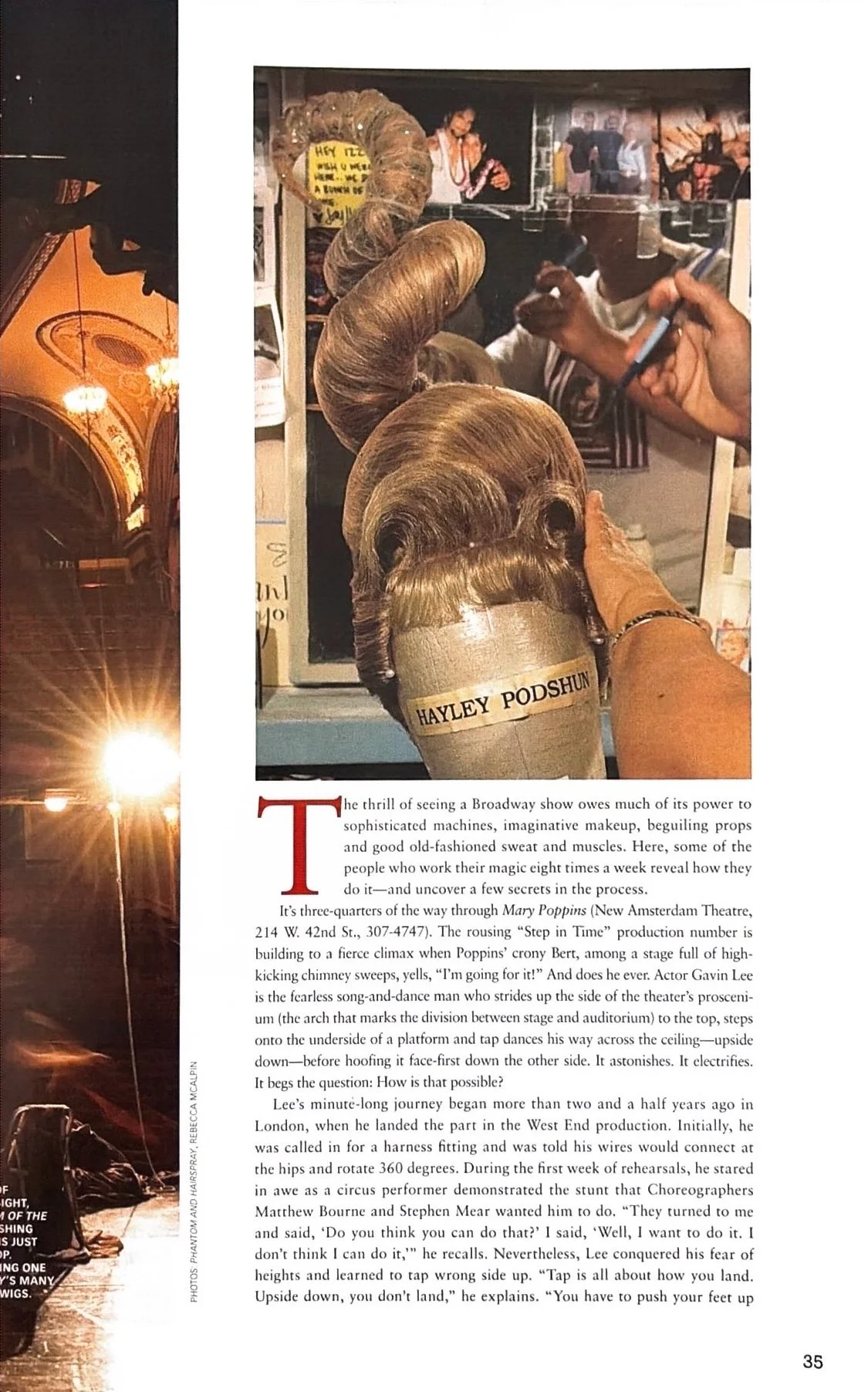 A magazine page featuring a photograph of a theatrical wig stylist working on a wig labeled "Hayley Podshun." The stylist's hand is holding a brush near the wig, with a mirror showing the stylist's reflection. The page includes a story about Broadway shows and the performing arts, with a large red initial letter "T" at the beginning of the paragraph.