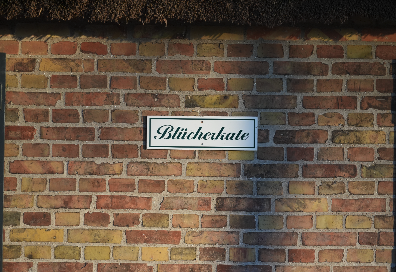 Straßenschild mit der Aufschrift 'Blücherhate' an einer Backsteinmauer
