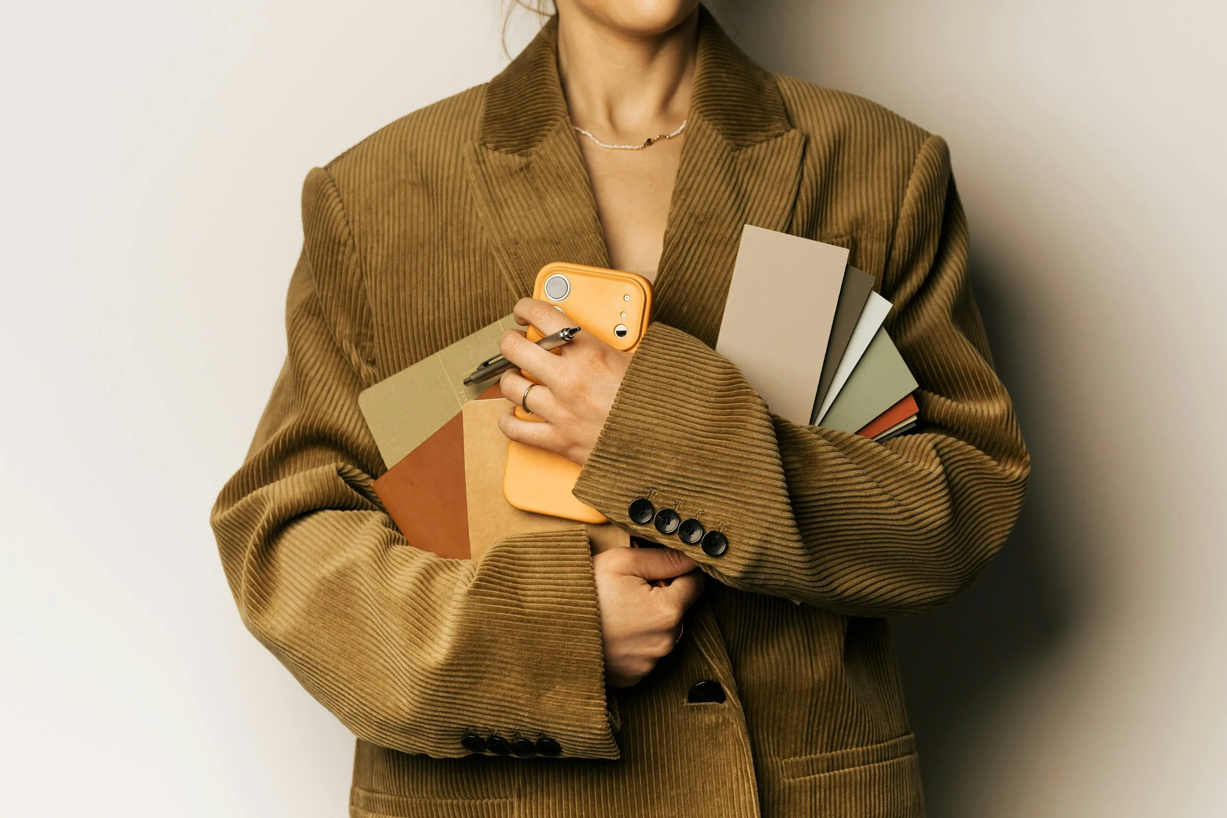 Femme portant un costume marron en velours côtelé qui cumule responsabilités professionnelles et vie de famille.