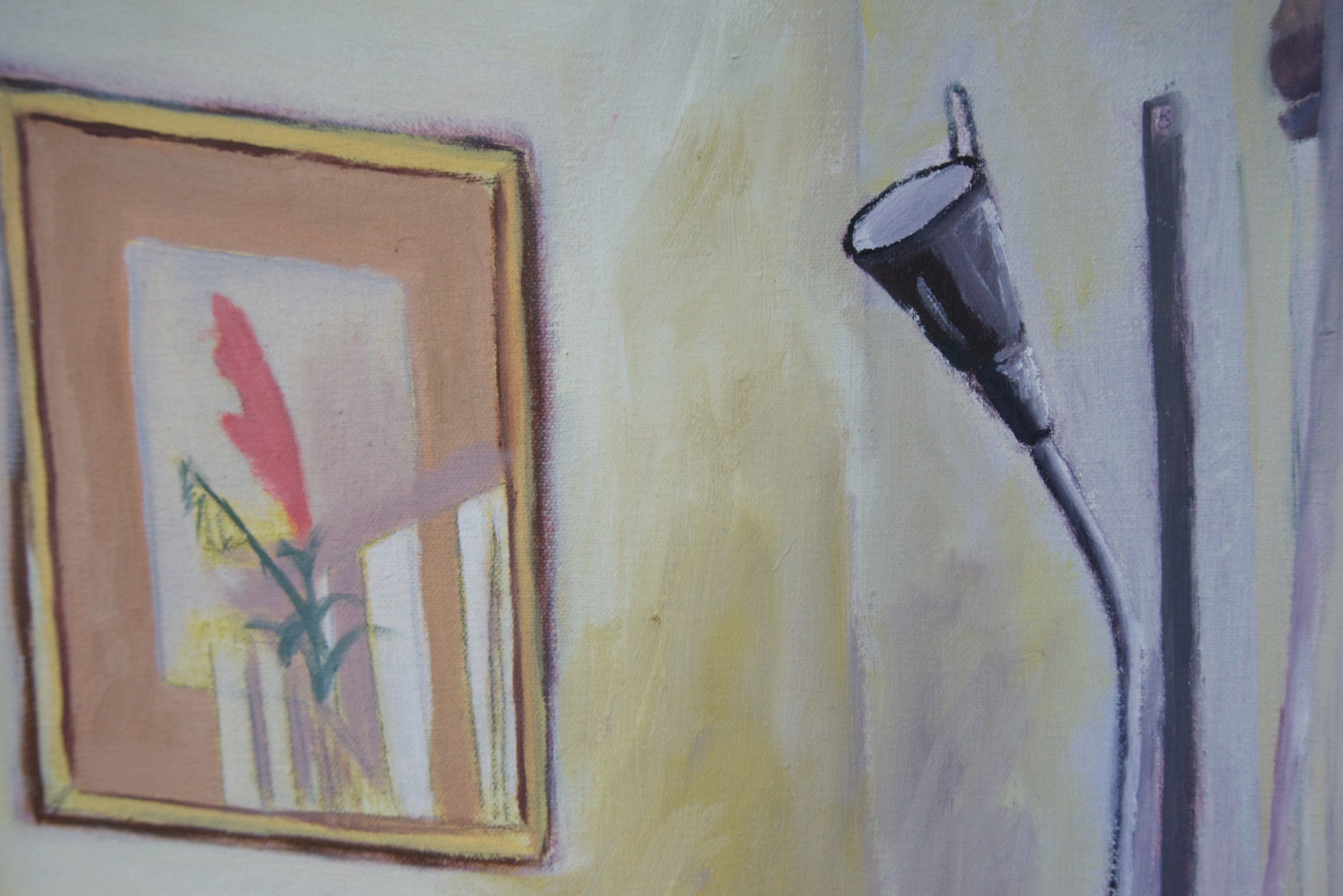 An indoor scene with a framed artwork of a flower on a yellow wall and a black microphone with a cable hanging nearby.