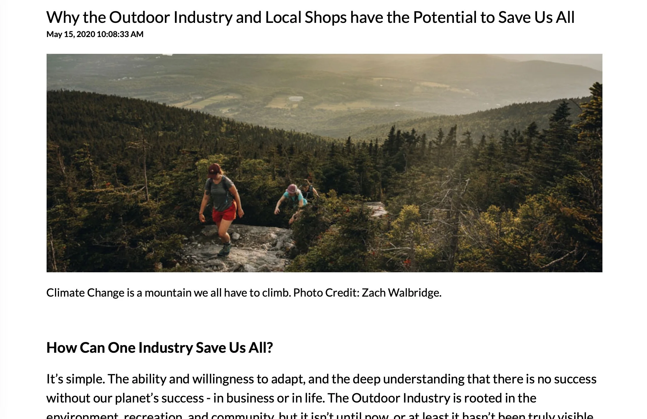 Three hikers climbing a rocky trail on a mountain surrounded by dense green trees, with a scenic view of a valley in the background.