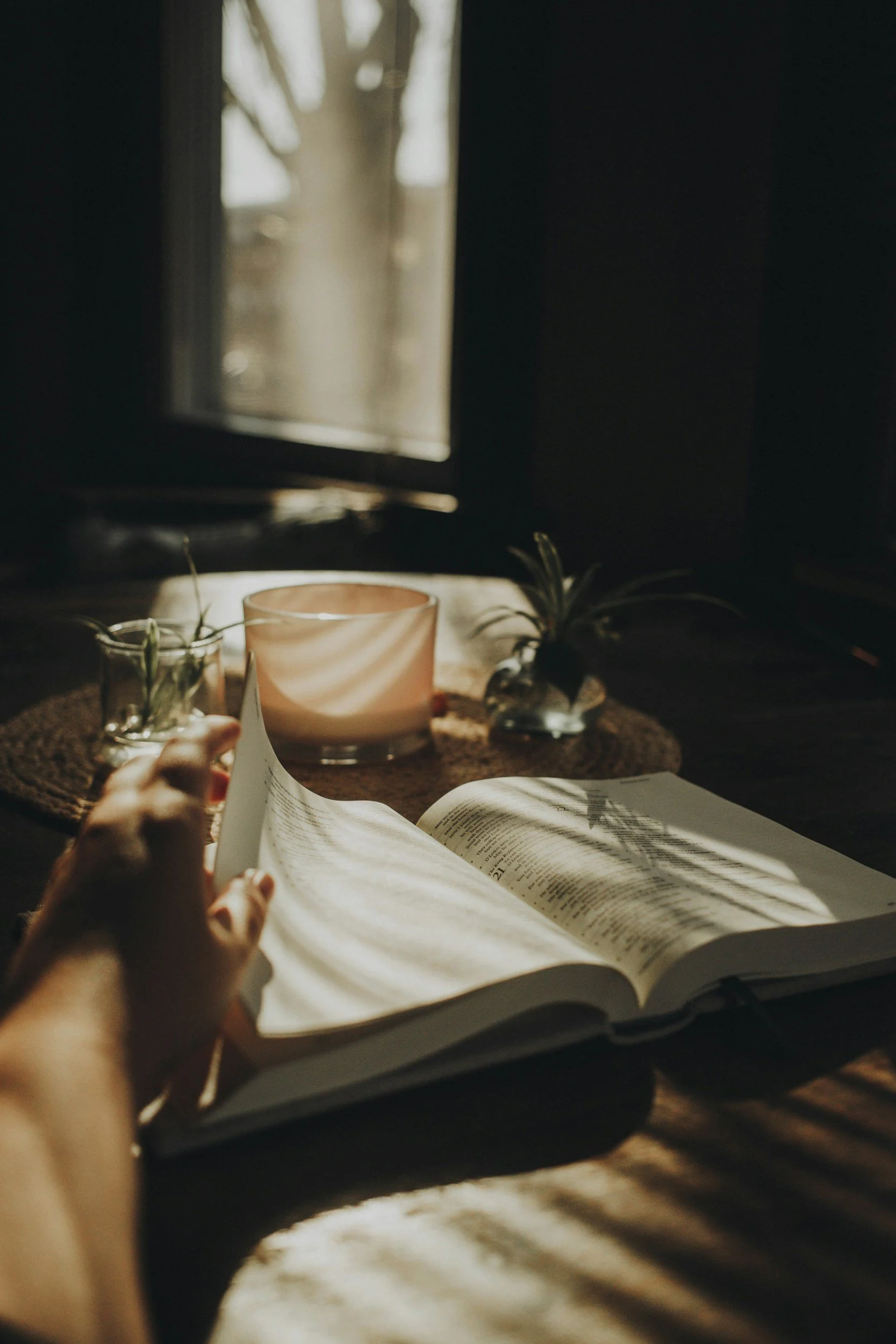 Woman journaling with a candle in the background