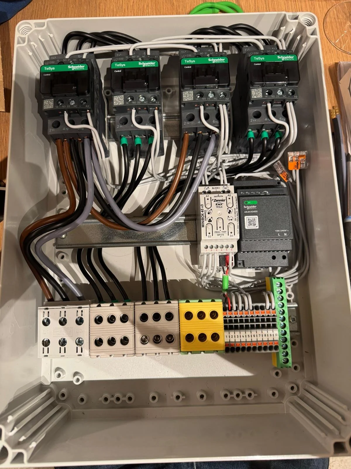 Electrical control panel with relays, terminal blocks, wiring, and circuit breakers.