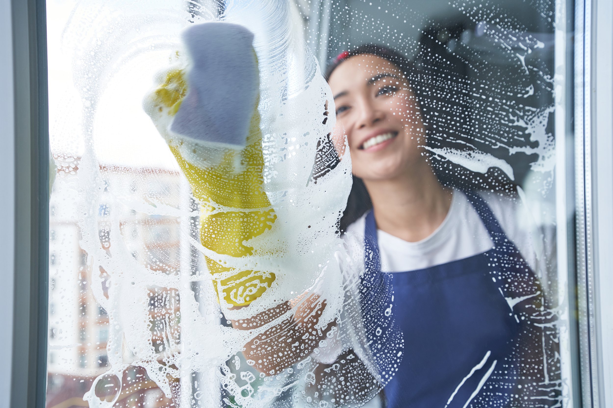 cheerful-young-woman-smiling-while-cleaning-the-wi-2026-01-09-07-27-25-utc.jpg