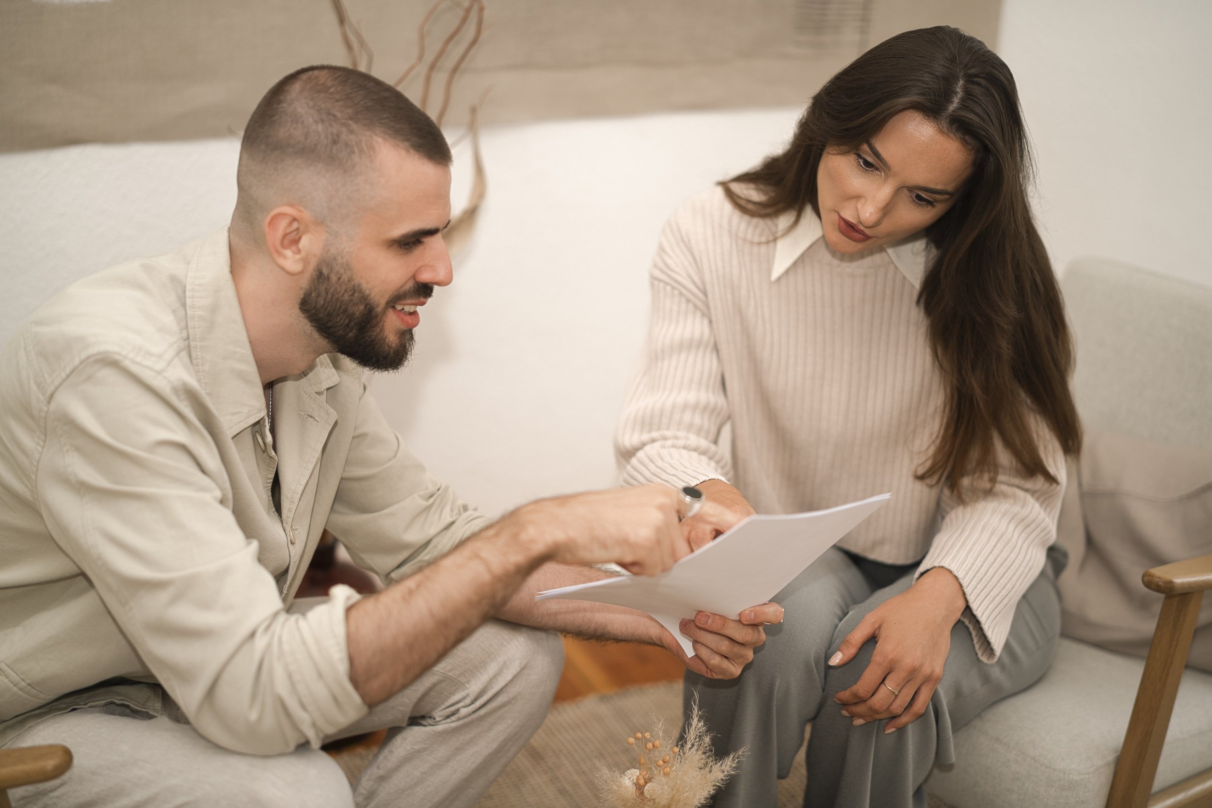 A portrait of am business man and business woman in berlin reading a paper for job interview.
