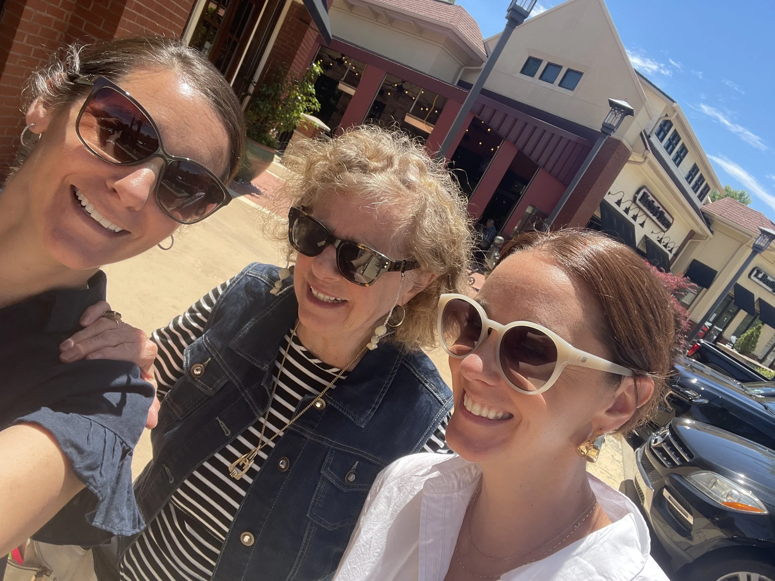 middle age daughters and mother all wearing sunglasses