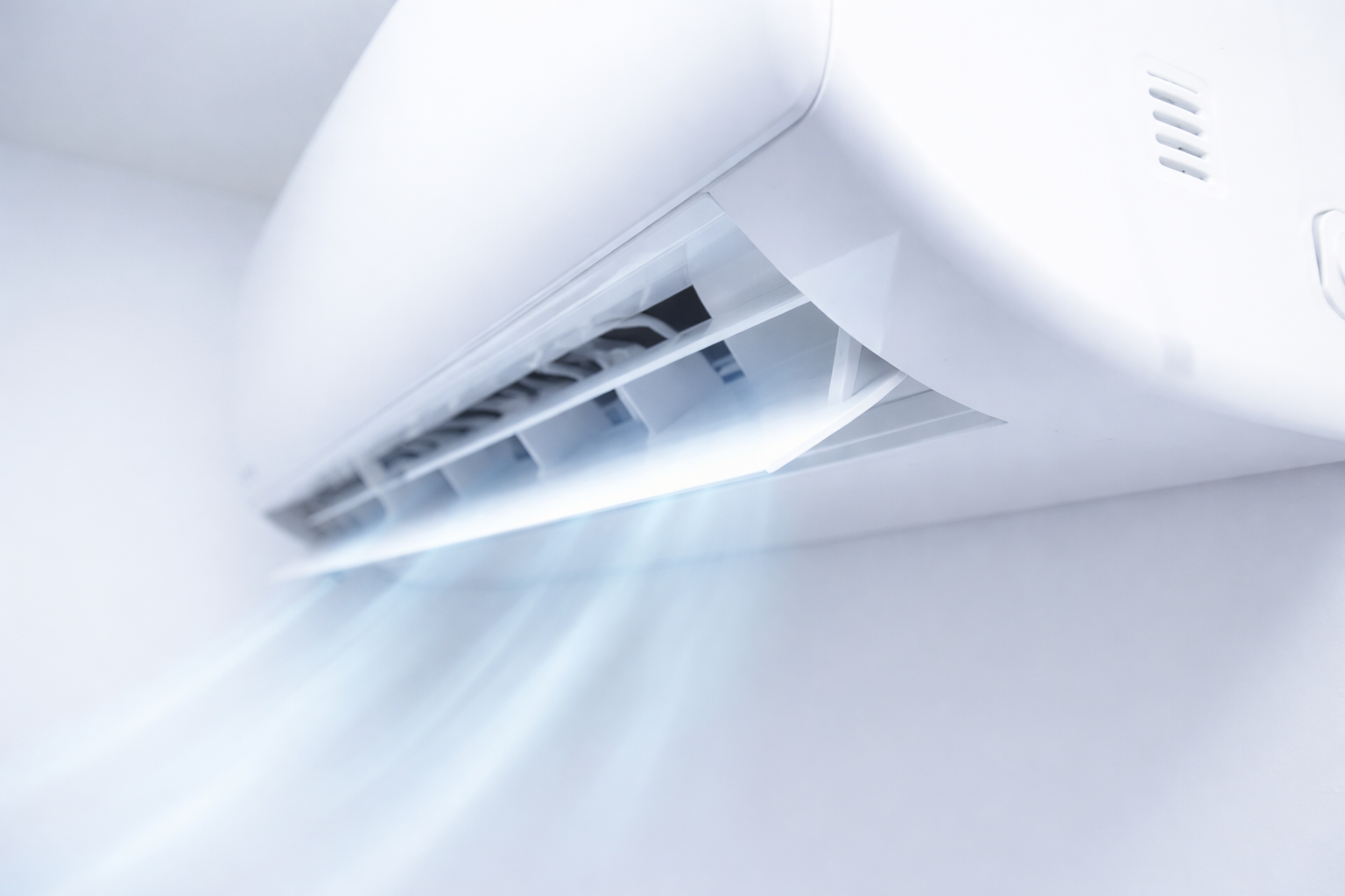 Climatisation murale blanche avec un flux d'air visible qui sort de ses évents.