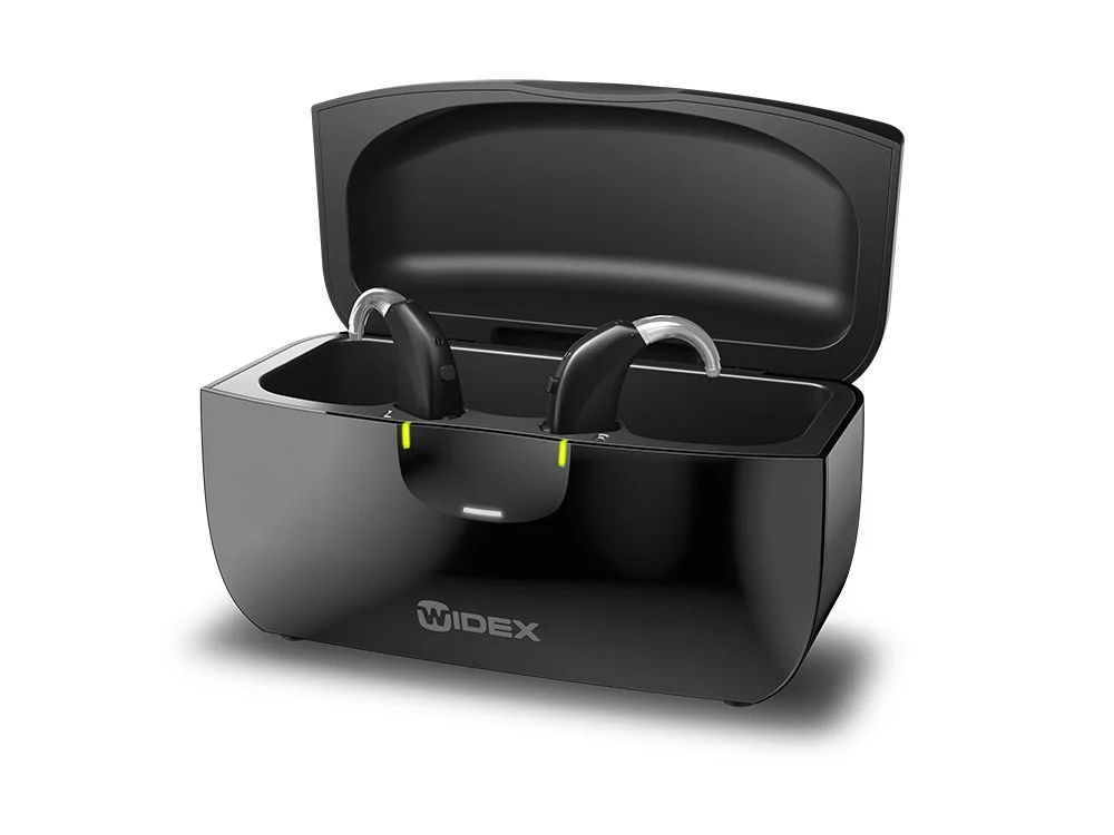 Une boîte de stockage pour appareils auditifs contenant deux appareils auditifs noirs avec des coques en plastique