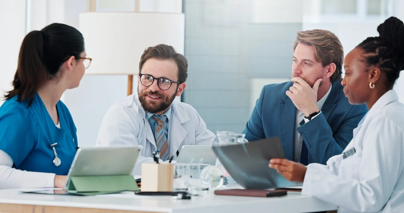 Medical team in a meeting in a bright, modern office discussing epic refuel program..