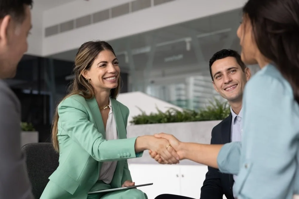 Healthcare IT consultants shaking hands during a meeting in an office.