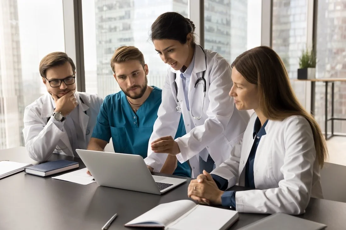 Medical team having a discussion about staffing shortages during a meeting in a modern office.
